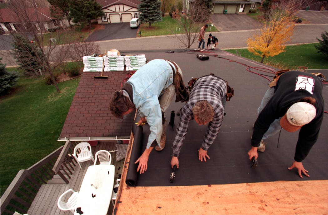A crew works on a roof in Shoreview in 1998.