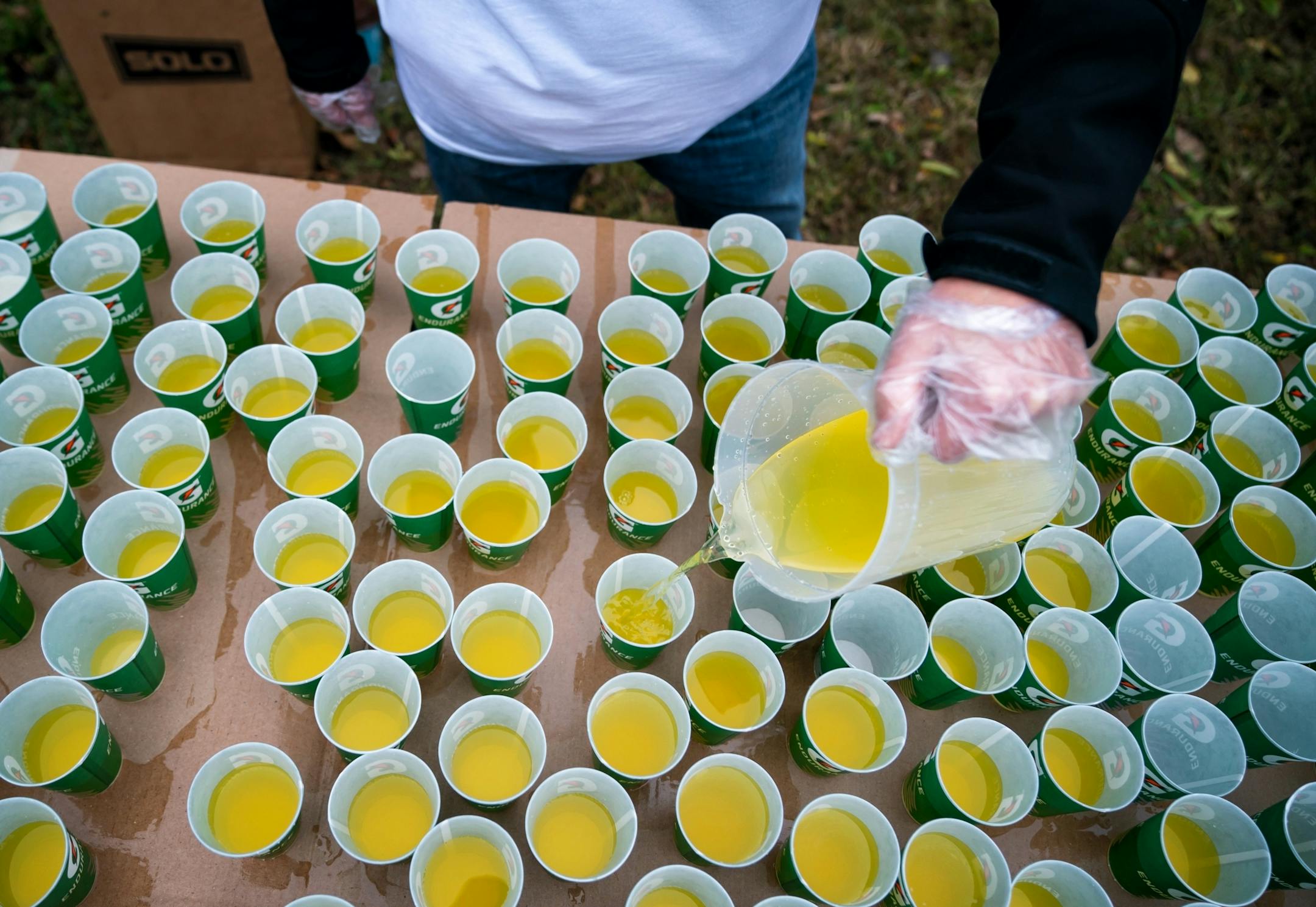 Volunteers poured gatorade at mile marker 11 on Cedar Ave just before the start the Twin Cities Marathon.