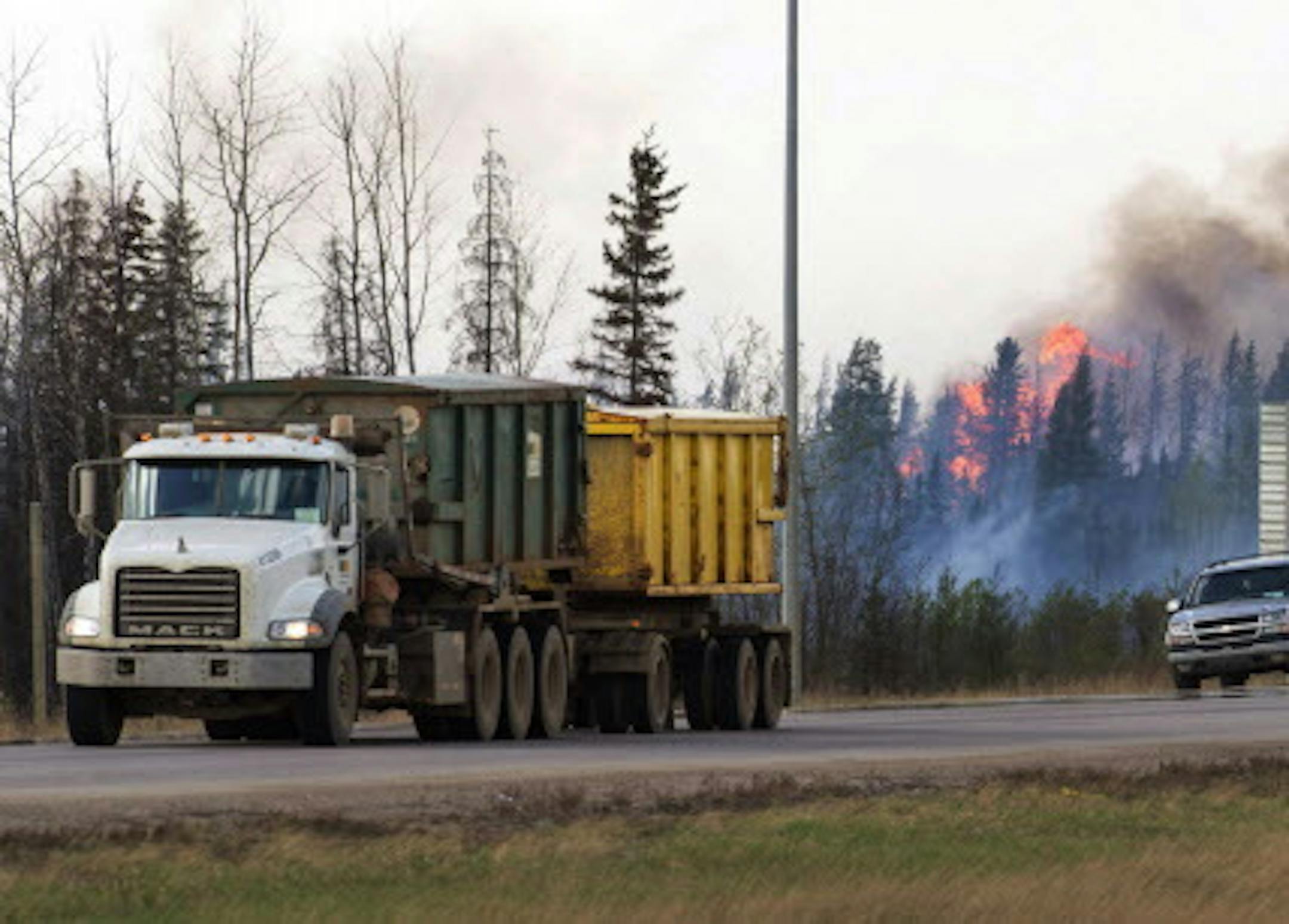 Flames flare up from hotspots along the highway to Fort McMurray, Canada, Sunday, May 8, 2016. (Ryan Remiorz/The Canadian Press via AP) MANDATORY CREDIT