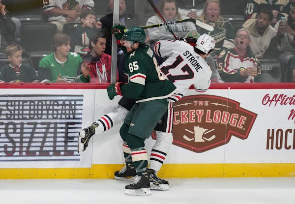 Minnesota Wild right wing Brandon Duhaime (65) crashed into the boards with Chicago Blackhawks center Dylan Strome (17) in the second period.