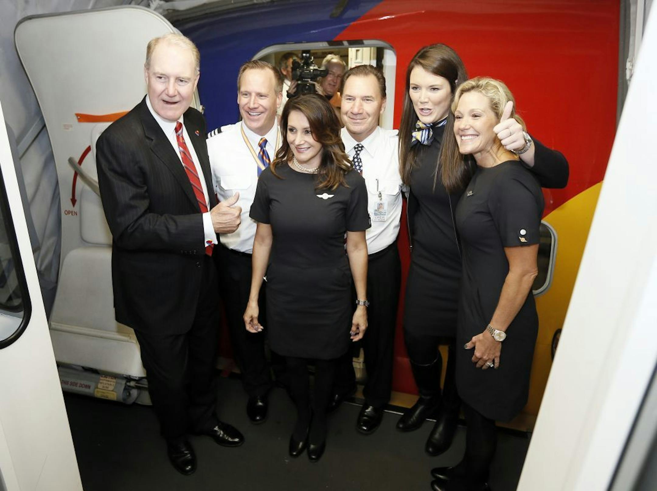 Southwest Airlines CEO Gary Kelly, left, poses with the flight crew for flight 1013 to Denver, the first non-restricted flight out of Dallas Love Field on Monday, Oct. 13, 2014 in Dallas.