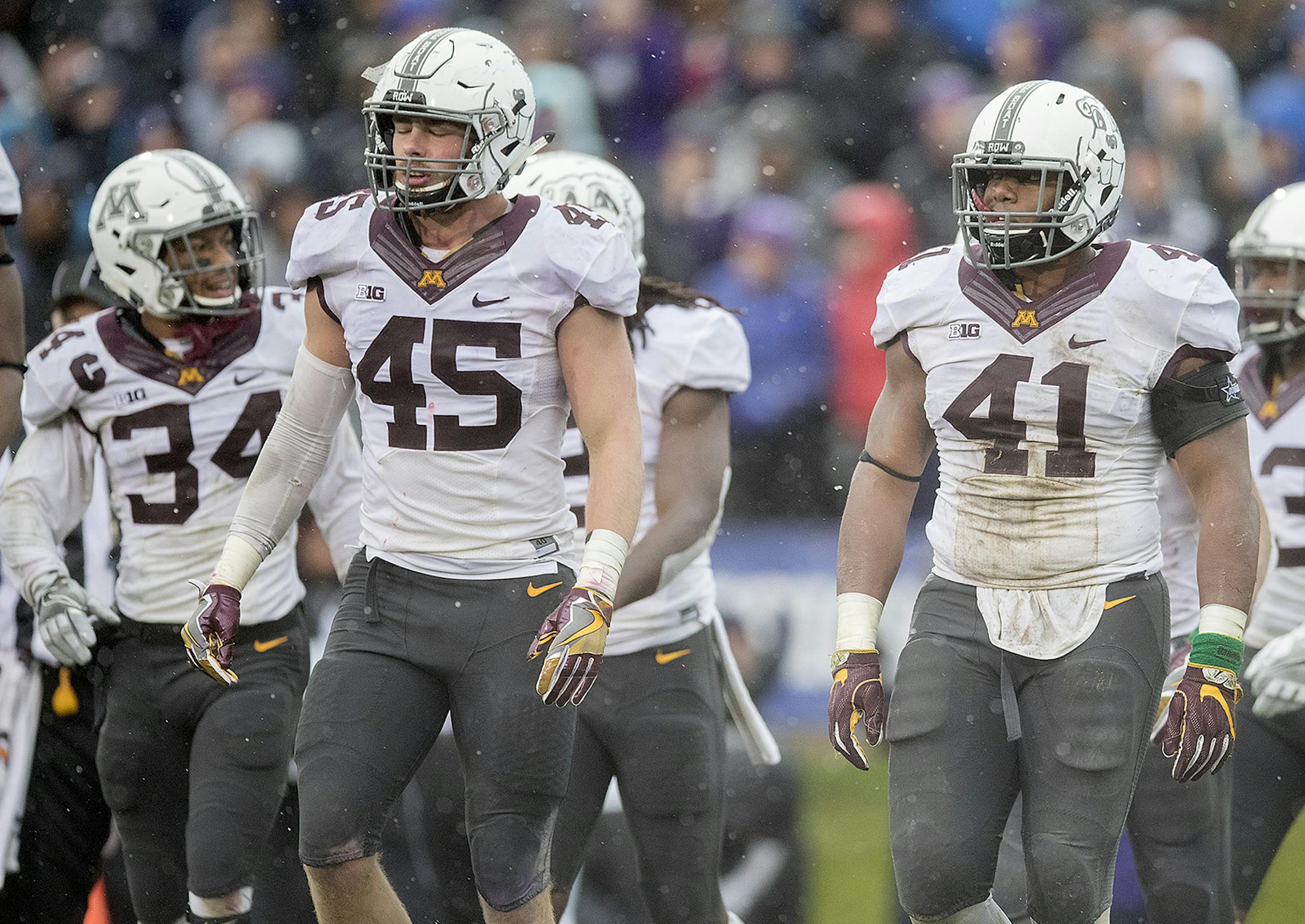 Minnesota's Antonio Shenault, left, linebacker Carter Coughlin, center, and Thomas Barber made their way off a rainy field after Northwestern scored a third touchdown during the second quarter as Minnesota took on the Northwestern Wildcats at Ryan Field, Saturday, November 18, 2017 in Evanston, IL. ] ELIZABETH FLORES ï liz.flores@startribune.com