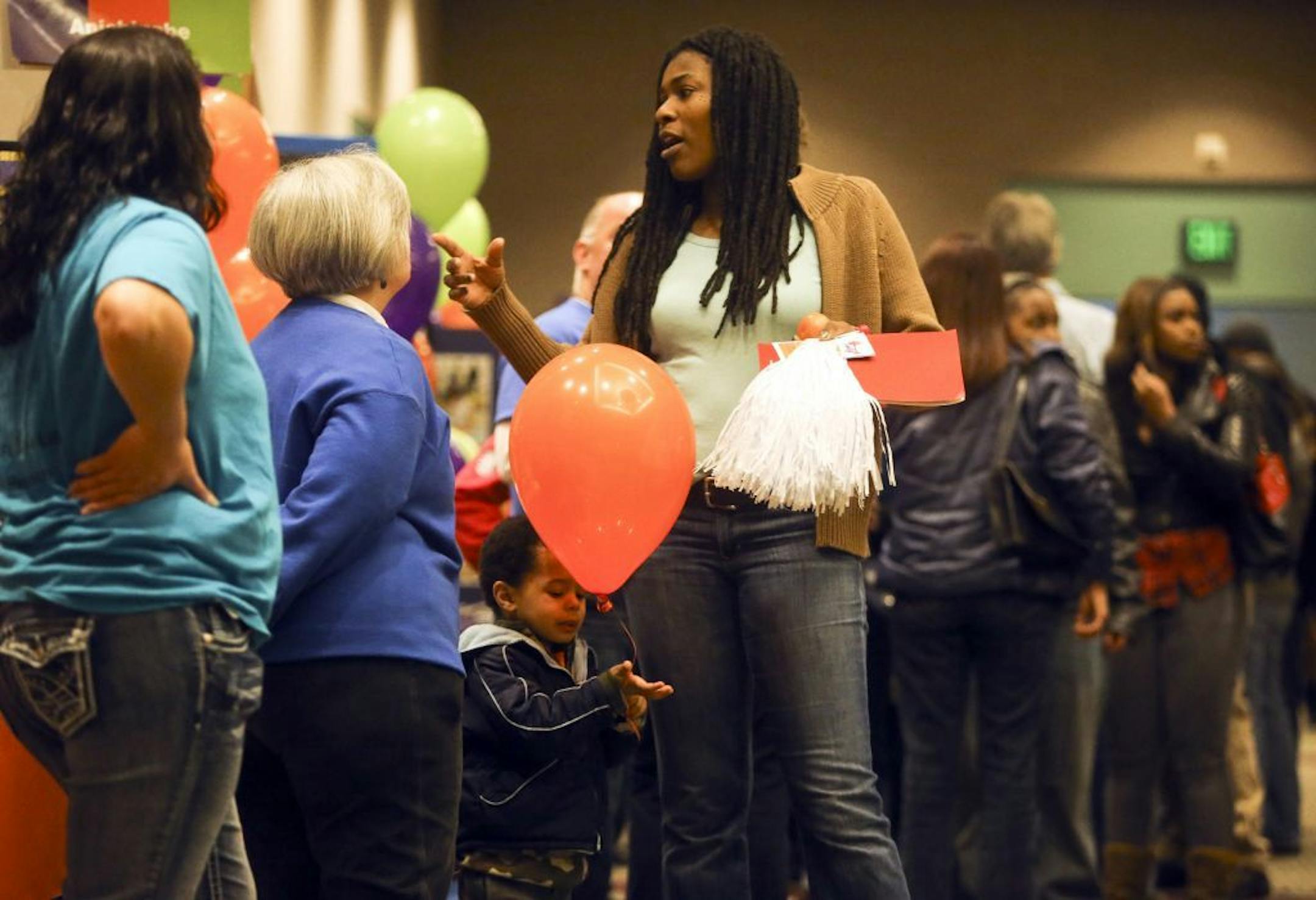 MPS mom Tracine Asberry, who is also a MInneapolis School Board member, chats while her son Miles Asberry-Wallace, 2, plays with a balloon Saturday, Jan. 25, 2014, at the School Choice fair at the Minneapolis Convention Center in Minneapolis, MN.