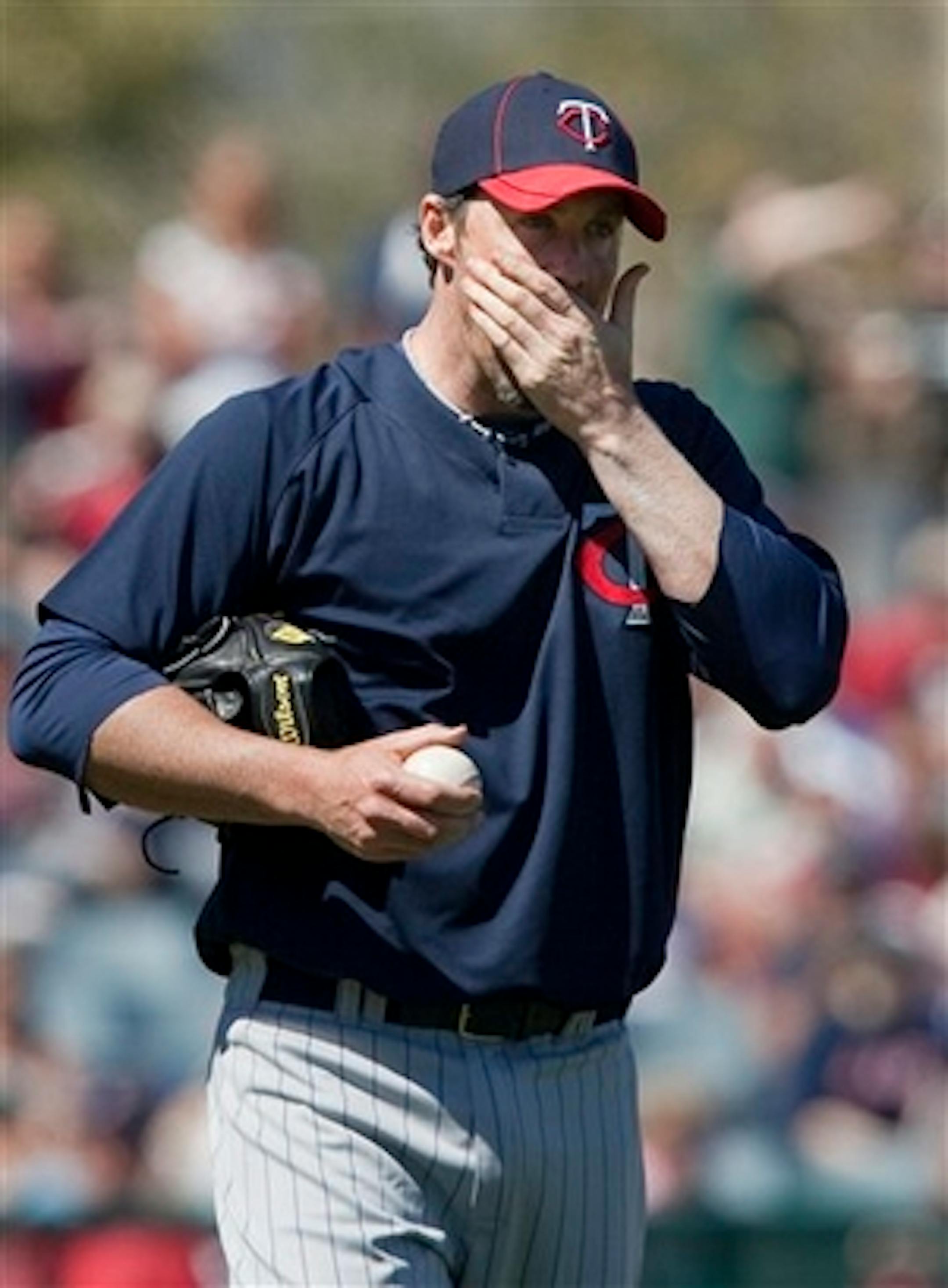 FILE-This March 6, 2010 file photo shows Minnesota Twins pitcher Joe Nathan wiping his face against the Boston Red Sox in the third inning of a spring training baseball game in Fort Myers, Fla.  Nathan, an All-Star closer,  has a torn ligament in his throwing elbow. The plan is to shut him down for two weeks before making any decisions about surgery.  (AP Photo/Nati Harnik,File)