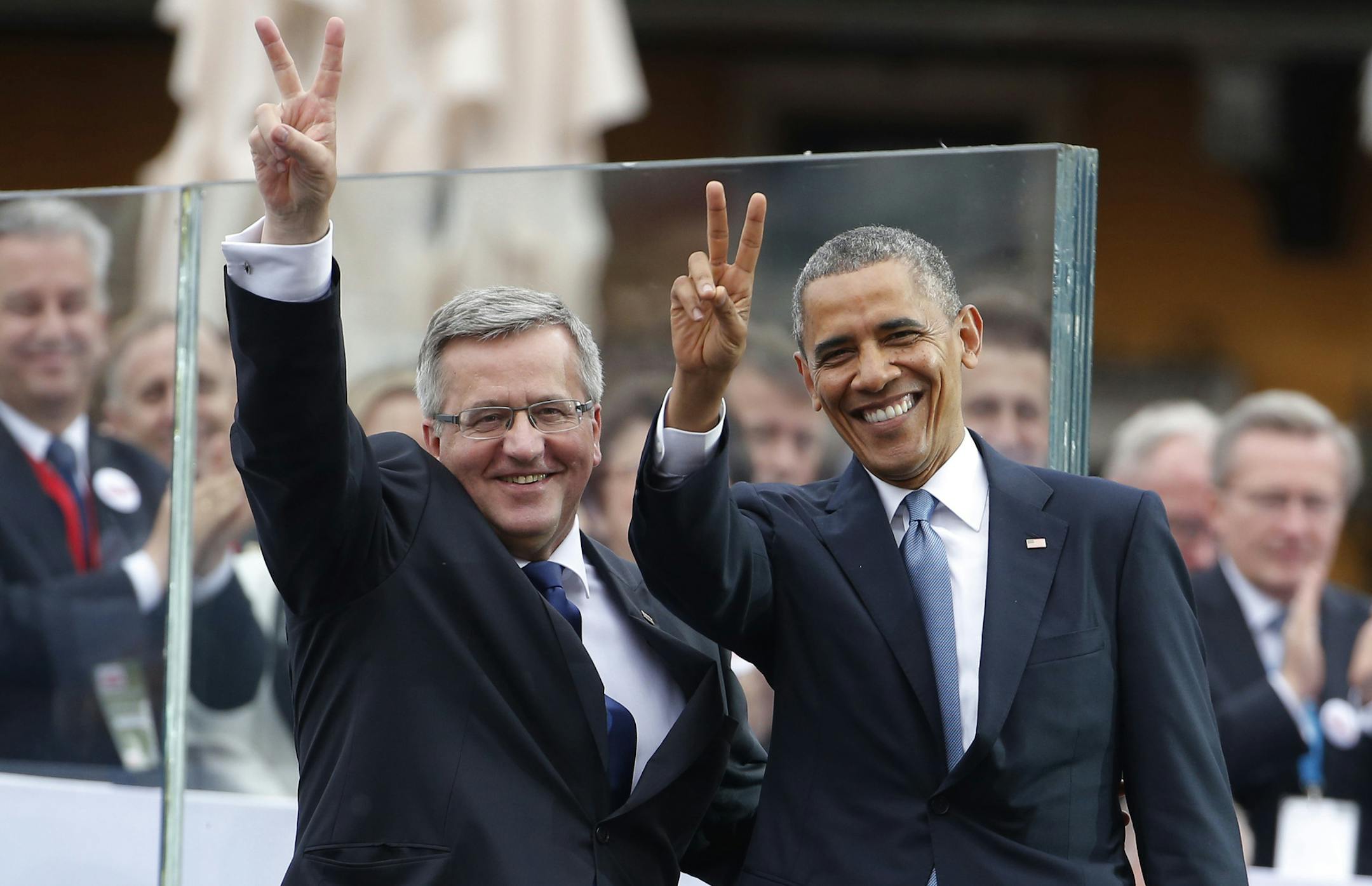 U.S. President Barack Obama, right, and Polish President Bronislaw Komorowski make the victory sign after Obama spoke at the 25th anniversary celebrations of Poland's first free elections led by the Solidarity movement at the Royal Square in Warsaw, Poland, Wednesday, June 4, 2014. (AP Photo/Charles Dharapak)