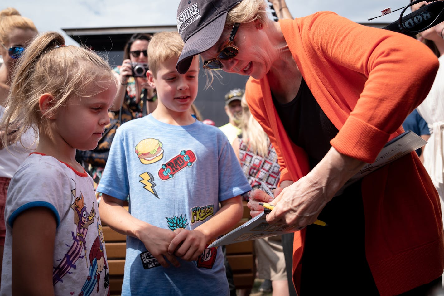 Sen. Elizabeth Warren (D-Mass.), a Democratic presidential hopeful, signs her autograph for young fairgoers at the Iowa State Fair in Des Moines, Iowa, on Aug. 10, 2019. (Erin Schaff/The New York Times)