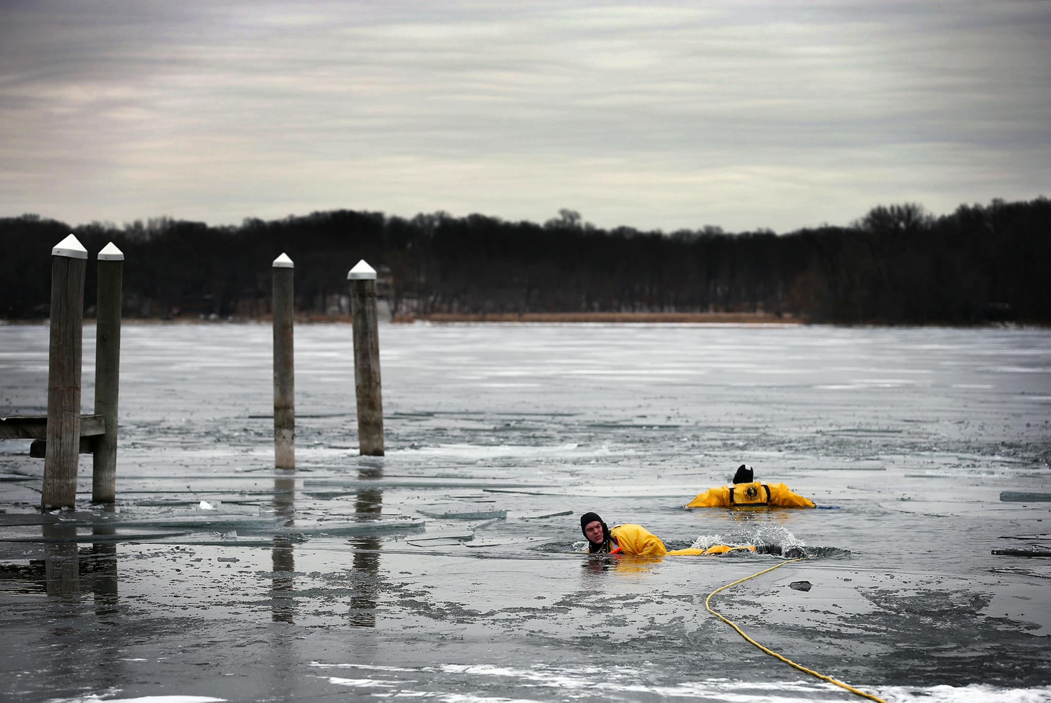 Justin Kaler, left, demonstrates an ice/water save with Syed Hussain, back to camera, both special deputies with the Hennepin County Sheriff's office at Tonka Bay Marina on Tuesday, November 25, 2014. ] LEILA NAVIDI leila.navidi@startribune.com /