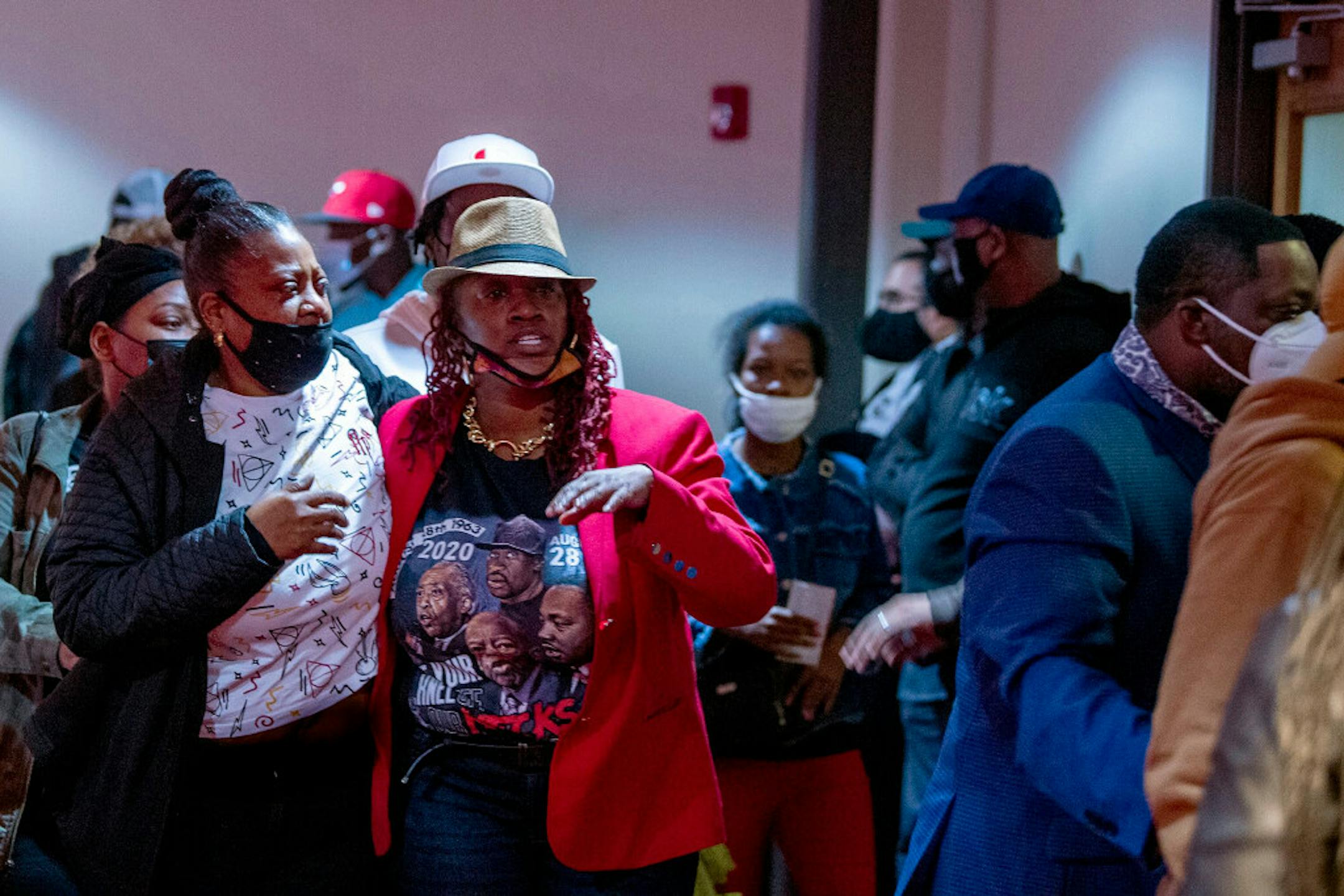 The family of Walter Wallace Jr. leaves a community meeting at the Church of the Christian Compassion in Cobbs Creek on Tuesday while State Sen. Anthony Williams shows a police body cam video of a white person being shot. The video was not from the Wallace shooting, but one Williams said community members asked him to play to show a police "double standard."
