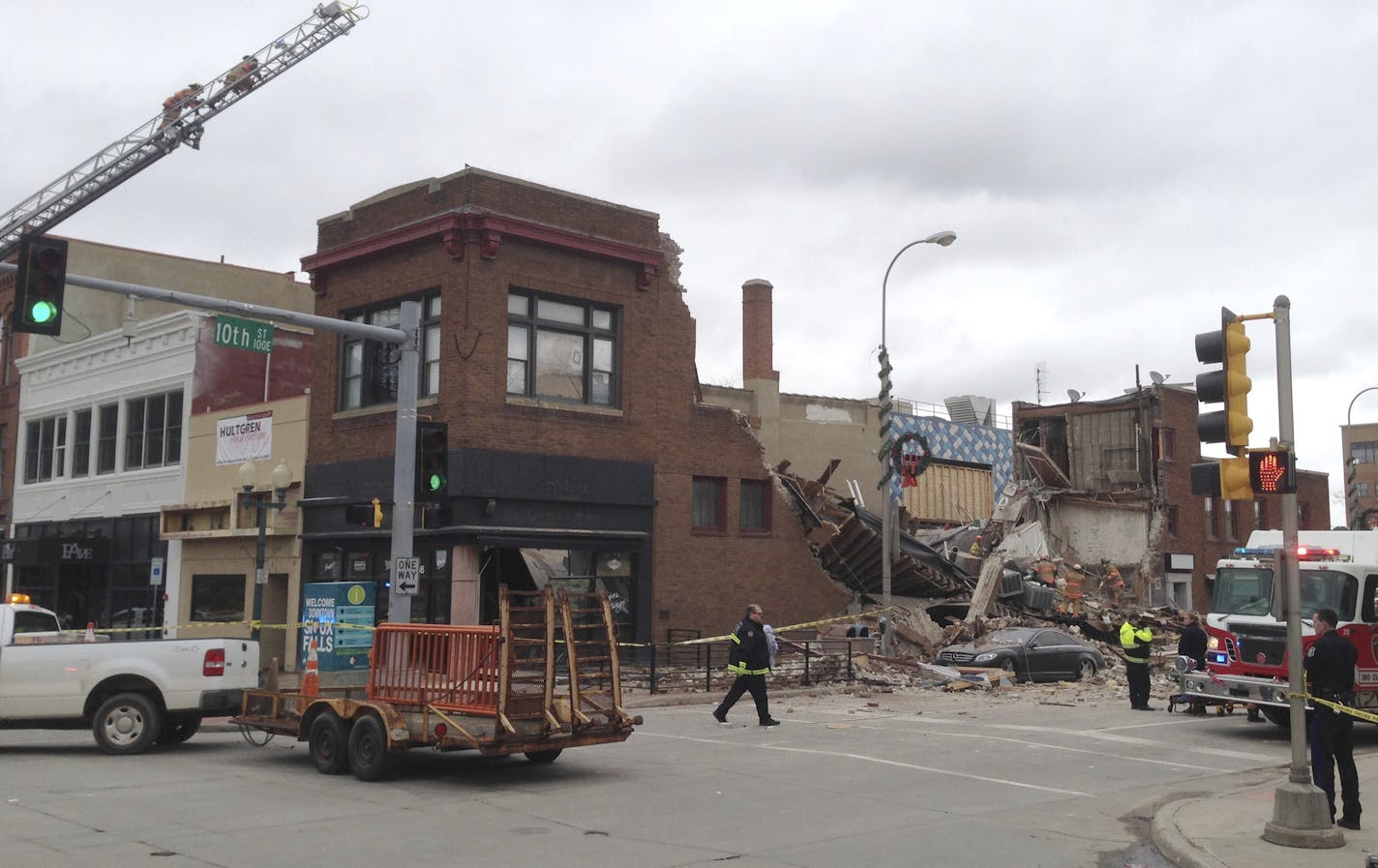 Emergency crews work to clear debris from after a building collapsed Friday Dec. 2, 2016 in downtown Sioux Falls. Two people were trapped inside the building, which was undergoing construction at the time of the collapse. A fire official says rescue workers are concerned about debris shifting as they try to free the people. (AP Photo/James Nord)