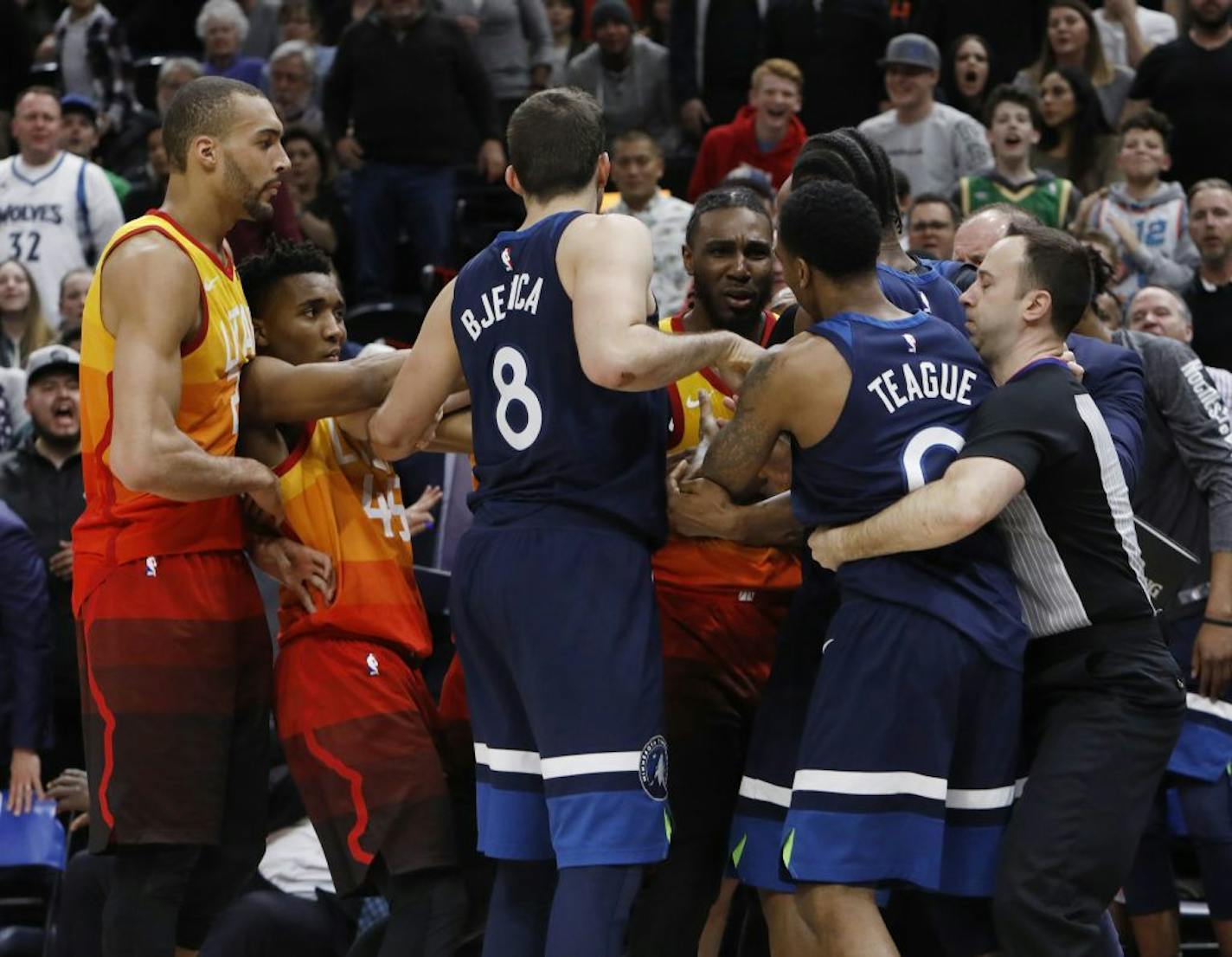 Minnesota Timberwolves' Jeff Teague (0) and Utah Jazz's Jae Crowder, back, tussle after Teague was called for a foul for pushing Utah Jazz's Ricky Rubio to the court during the second half of an NBA basketball game Friday, March 2, 2018, in Salt Lake City. Teague was called for a flagrant foul and ejected following the fight on the court. The Jazz won 116-108.