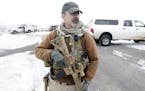 A man stands guard after members of the "3% of Idaho" group along with several other organizations arrived at the Malheur National Wildlife Refuge nea