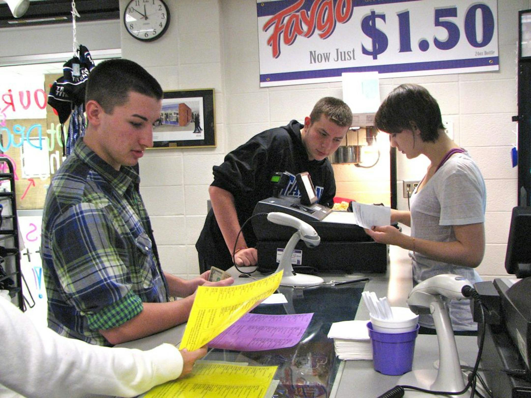 Credit: Kaitlyn WalshJunior Taylor Oilen (right) takes the wing order of the school-run company's president, 16-year-old Marco Buchmayer (left), Monday.