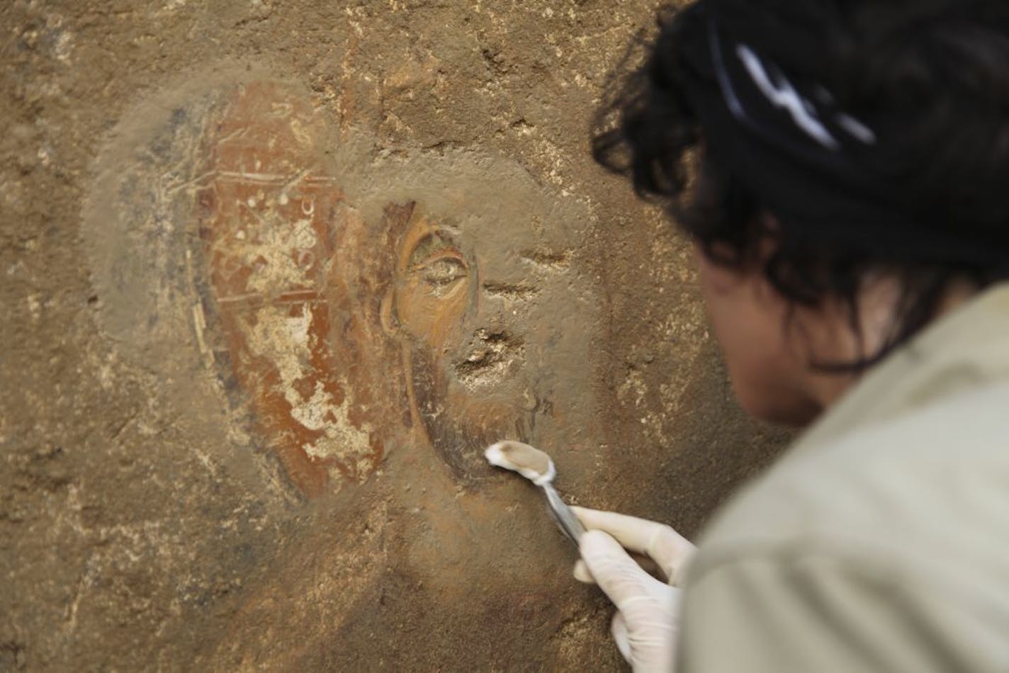 In an undated handout photo, a restorer cleans a preserved deesis fresco that appears under alluvium at an excavation site in Turkey. The excellent condition of a newly discovered 13th-century chapel has stirred hopes among archaeologists that an entire city may be largely intact underground. (Myra-Andriake Excavations via The New York Times) -- NO SALES; FOR EDITORIAL USE ONLY WITH STORY SLUGGED SCI TURKEY EXCAVATION BY JENNIFER PINKOWSKI. ALL OTHER USE PROHIBITED.