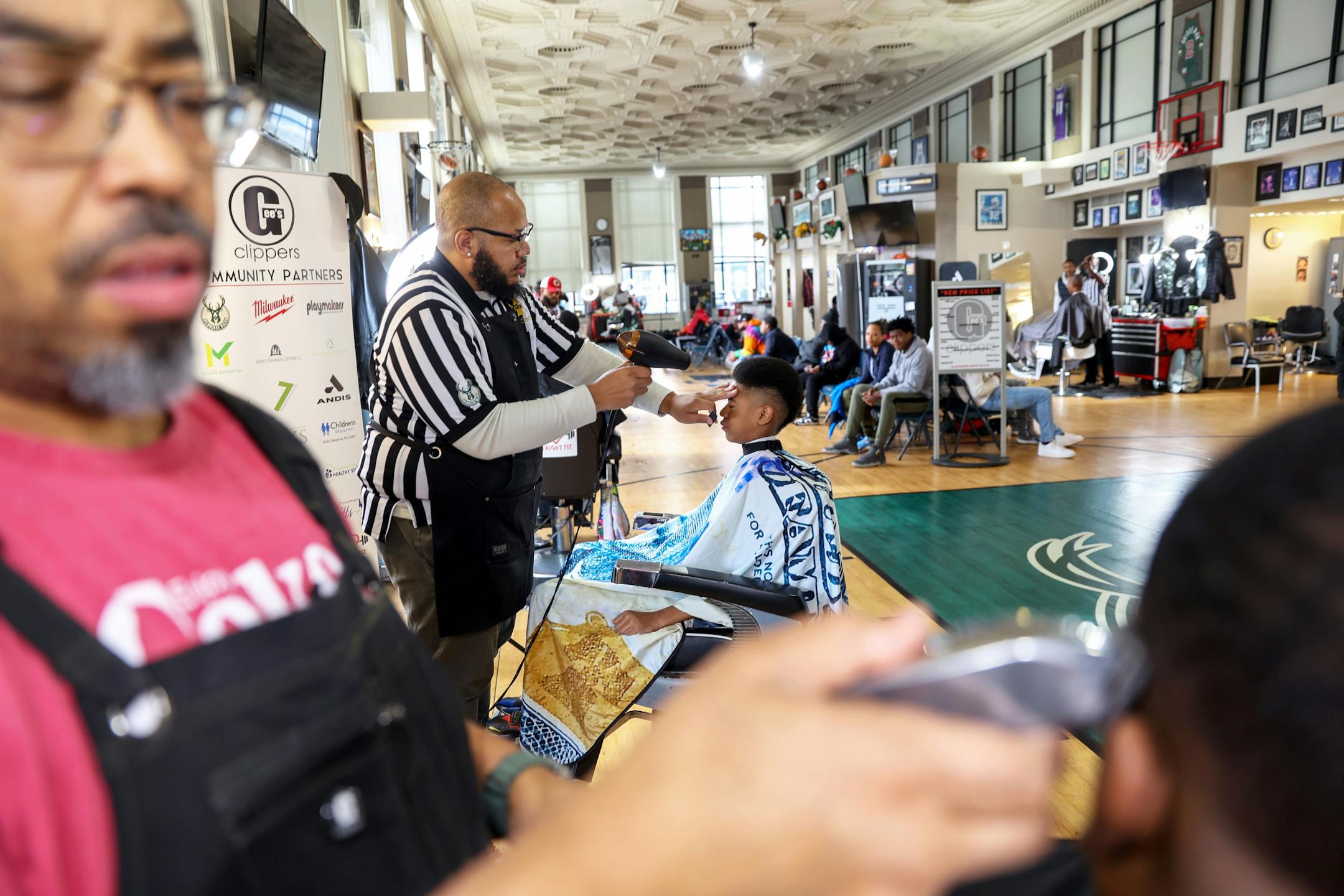 Barbers cut hair at Gee's Clippers, a basketball-themed barbershop in Milwaukee. MUST CREDIT: Alex Wroblewski for The Washington Post
