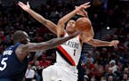 Minnesota Timberwolves center Gorgui Dieng, left, knocks the ball away from Portland Trail Blazers guard Anfernee Simons during the second half of an 