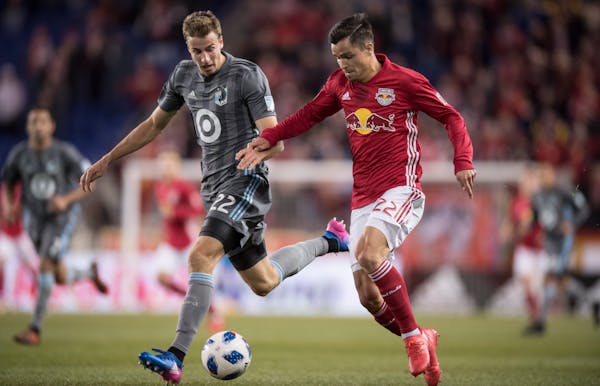 Wyatt Omsberg #22 of Minnesota United FC battles for the ball with Florian Valot #22 of New York Red Bulls during a regular season game at Red Bull Ar