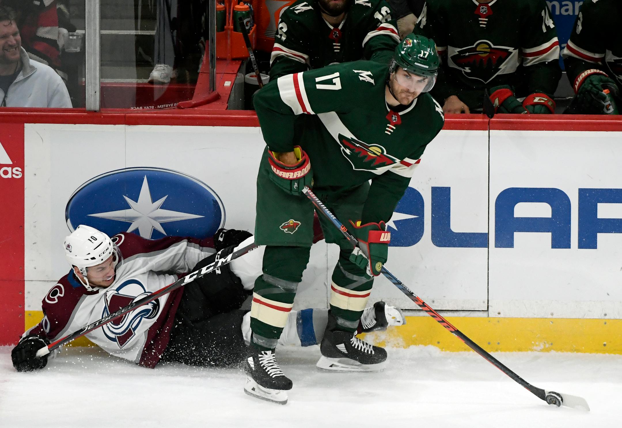 Colorado Avalanche's Sven Andrighetto (10), of Switzerland, crashes into the boards as Minnesota Wild's Marcus Foligno (17) takes the puck during the first period of an NHL hockey game Saturday, Oct. 27, 2018, in St. Paul, Minn. (AP Photo/Hannah Foslien)