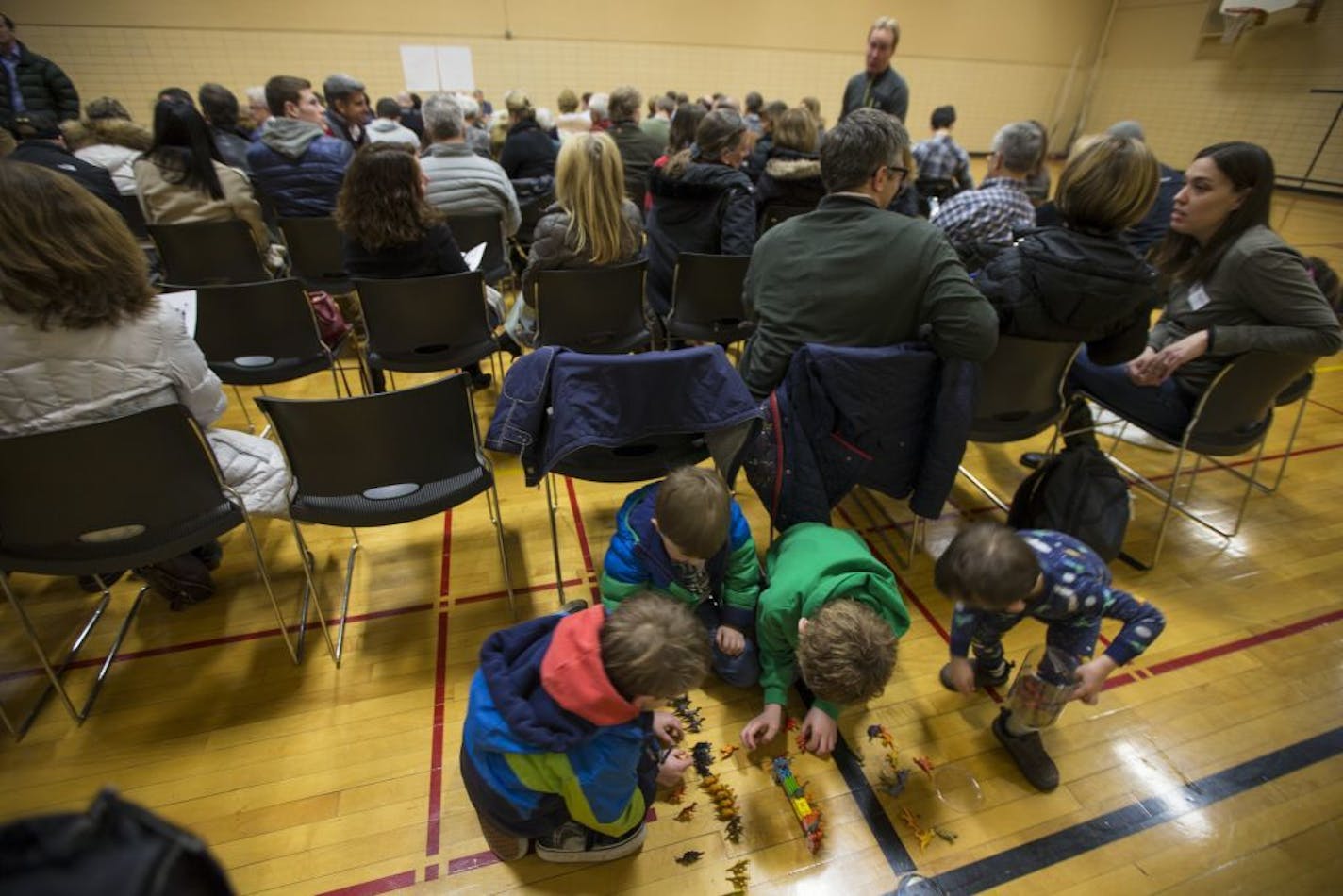 A group of children patiently played with dinosaurs during a GOP precinct caucus for precinct 3 at South View Middle School on March 1, 2016, in Edina, Minn.