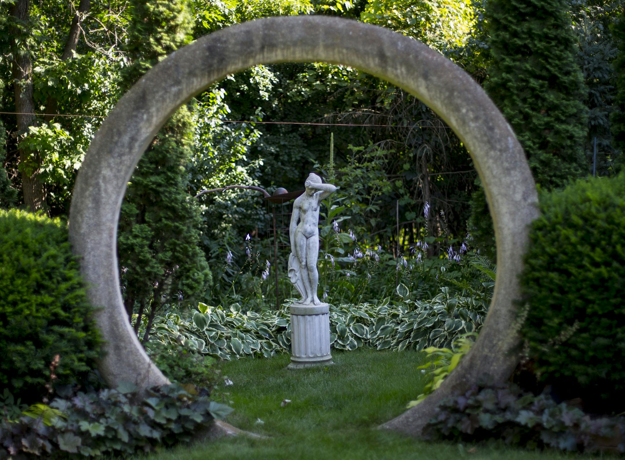 A statue is framed by a stone circle in Tom Hayden and Jay Peterson's back yard.