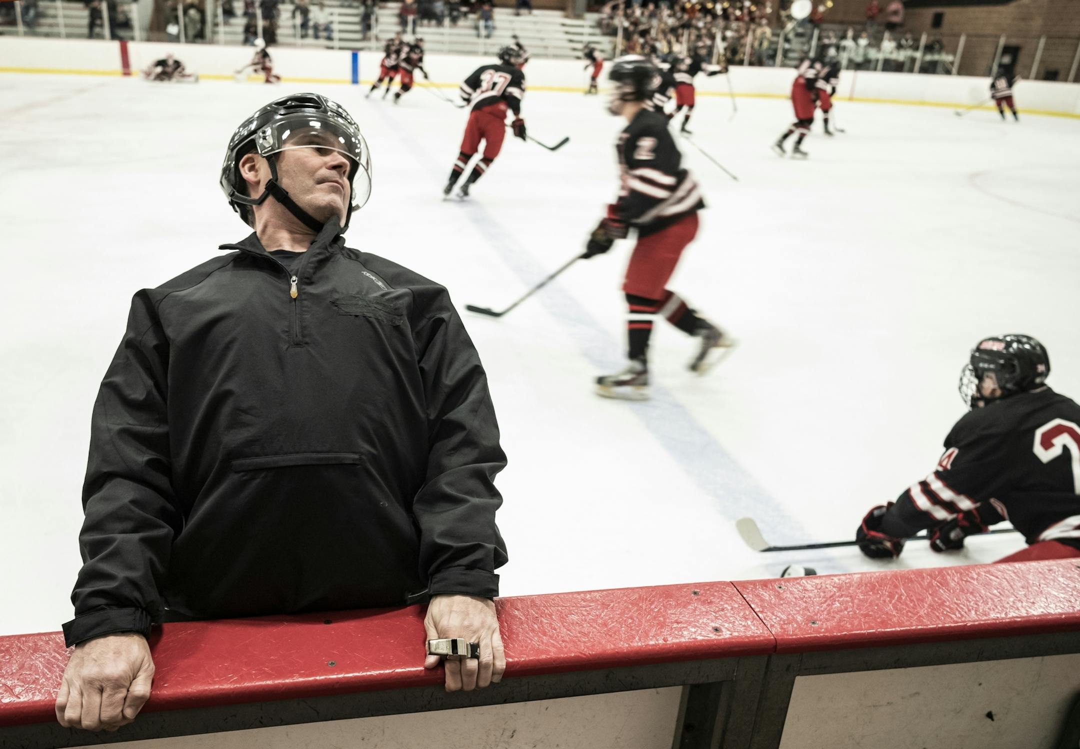 "USA Hockey and High School Hockey devote a great deal of time instructing both players and coaches on the protection of yourself and opponents near the boards, " says C.J. Beaurline who stretches out before the game. He recently broke his ribs and is still recovering. He has over 20 years of experience as an official. He also works Gophers' hockey games on the weekend.