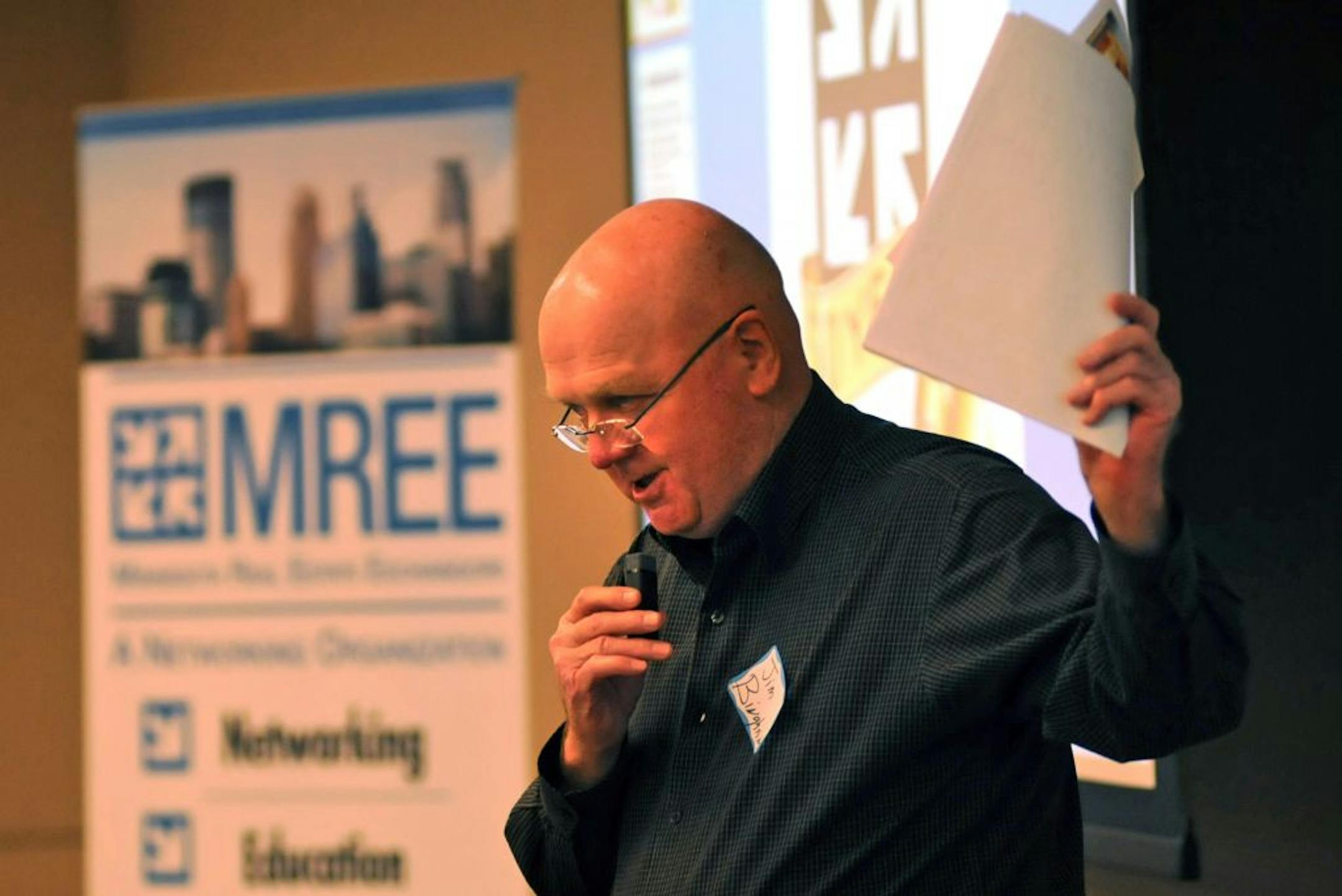 Jim Bingham of Redwing held up a Have /Want property listing during a exchange session. The Minnesota Real Estate Exchangors, a group of real estate professionals, is celebrating its 50th anniversary this year. The group is known for its Have/Want exchange among members at each meeting. In this exchange, moderated by MREE President Neil Friedman, real estate brokers and financiers make presentations on behalf of their clients with an eye towards making a match and doing a deal..