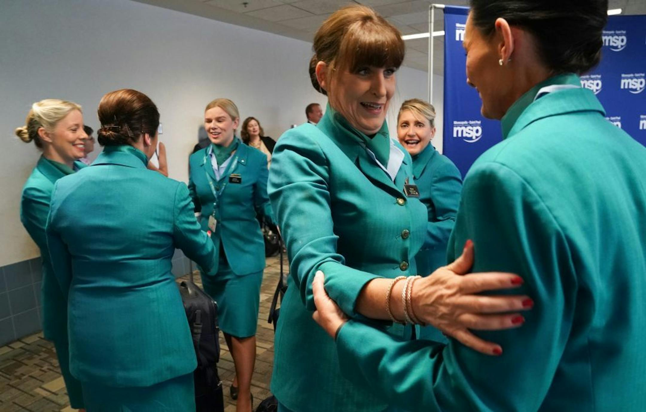 Aer Lingus flight attendants for return trip to Dublin, greeted each other before the flight touched down. The first direct Aer Lingus flight from Dublin landed at Minneapolis St. Paul International Airport. It received a water canon welcome from the Airport fire Department and the Mall of America brought SpongeBob SquarePants and handed out gift bags. Sweet Retreat Cupcake Boutique provided specially designed cupcakes and a special cake with landmarks from Minneapolis and Dublin.