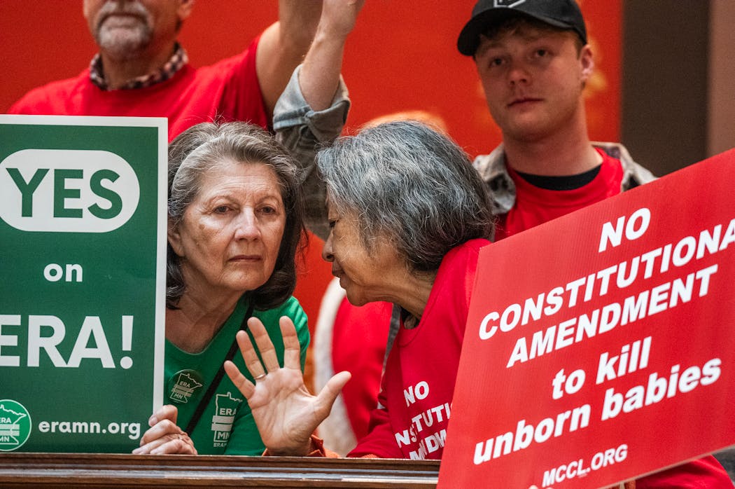 Pauline Wahl, left, and Judy Caravalho, on opposite sides of the ERA debate, havve a friendly discussion as protesters gathered outside the Senate chambers on Monday.