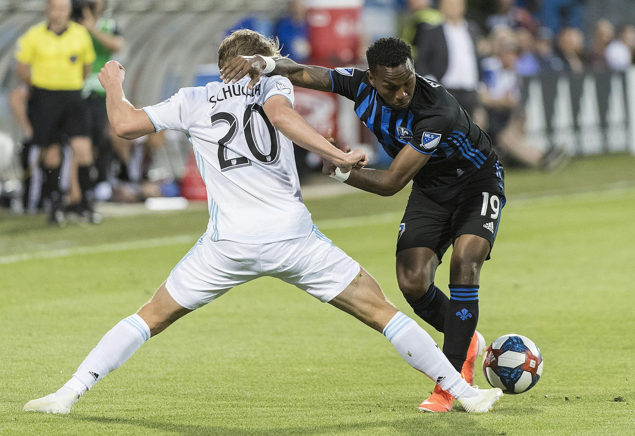 Montreal Impact's Omar Browne (19) andMinnesota United's Rasmus Schuller (20) go for the ball during the second half of an MLS soccer match Saturday, July 6, 2019, in Montreal. (Graham Hughes/The Canadian Press via AP)