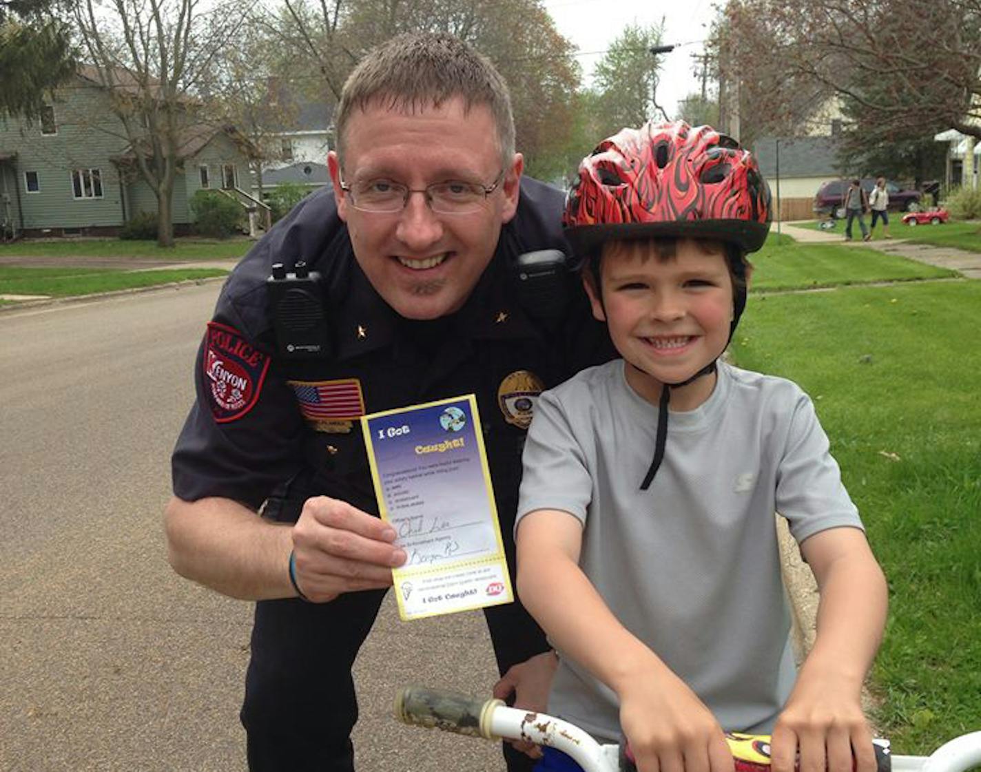 Kenyon Police Chief Lee Sjoland "tickets" at young bike rider for wearing a helmet, in this photo on the department's Facebook page. The "ticket" is good for free ice cream at Dairy Queen.