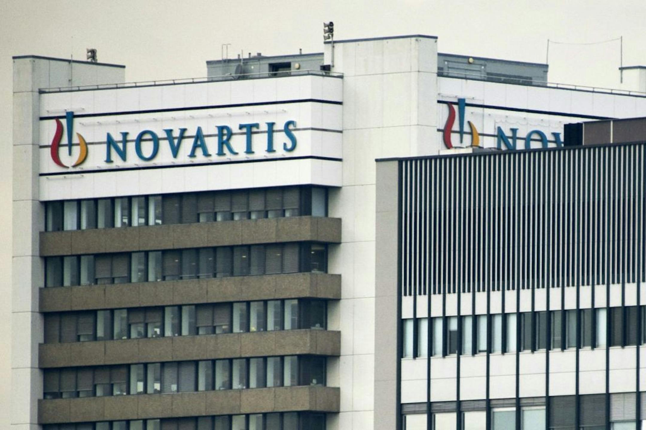FILE - This Oct. 25, 2011 file photo shows the logo of Swiss pharmaceutical company Novartis AG on one of their buildings in Basel, Switzerland. According to results published Sunday, Aug. 27, 2017, for the first time, a drug has helped prevent heart attacks by curbing inflammation, a new and very different approach than lowering cholesterol, which has been the main focus for decades. Canakinumab's maker, Novartis, sponsored the study.