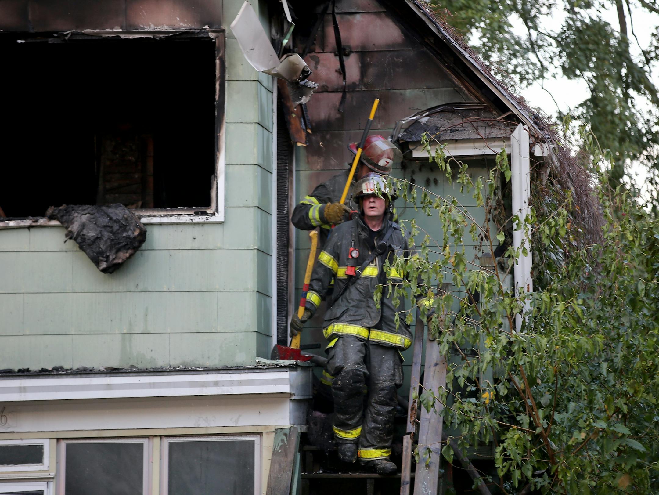 Minneapolis firefighters leave the charred upstairs a duplex gutted by fire Thursday, Sept. 28, 2017, in Minneapolis, MN.