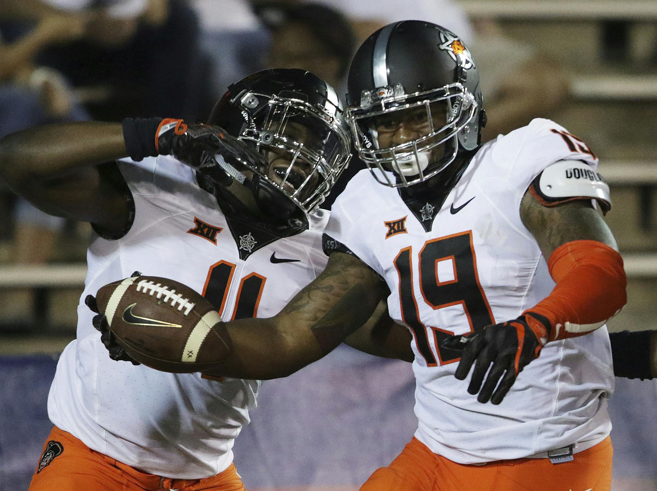 Oklahoma State linebacker Justin Phillips, right, celebrates his interception return for a touchdown against South Alabama with linebacker Amen Ogbongbemiga, during the second half of an NCAA college football game, Friday, Sept. 8, 2017, in Mobile, Ala. Oklahoma State won 44-7. (AP Photo/Dan Anderson)