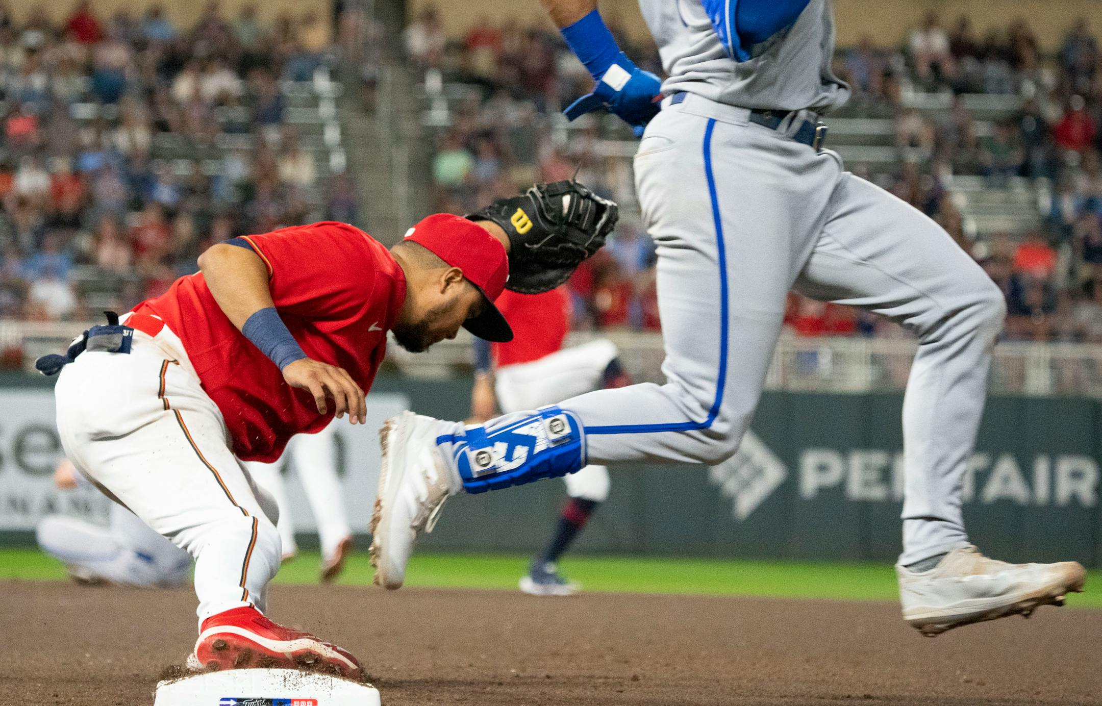 Minnesota Twins second baseman Luis Arraez (2) completes a double play as Kansas City Royals right fielder Hunter Dozier (17) is called out in the seventh inning.