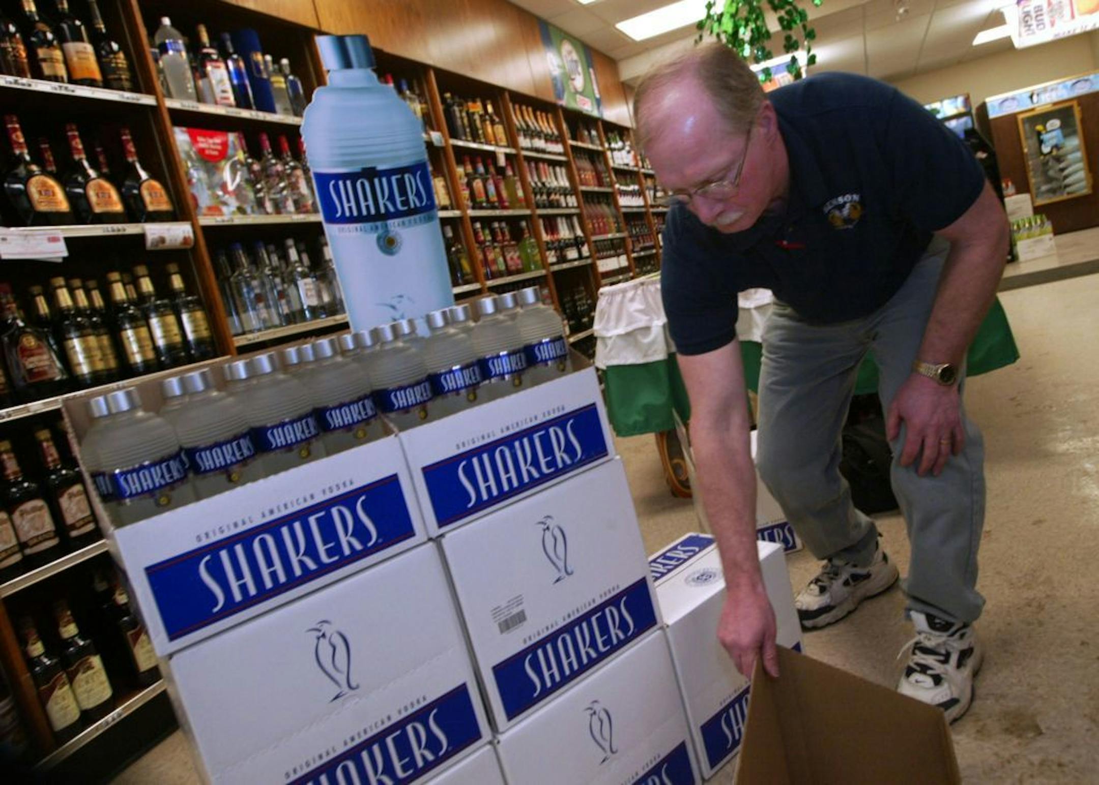 Pat McGeary, manager of Benson Municipal Liquor Store, is trying to keep up with demand after a record sellout of 40 cases in the first week of Shakers' retail sales. He's now selling his second shipment. Above, McGeary rearranges the Shakers' display after a run on the vodka one recent afternoon. GENERAL INFORMATION: 3/3/03- Farmers in Benson, MN have teamed up with New York distributors to produce an ultra-premium vodka from wheat in an ethanol plant in Benson. it just hit the shelves in the l