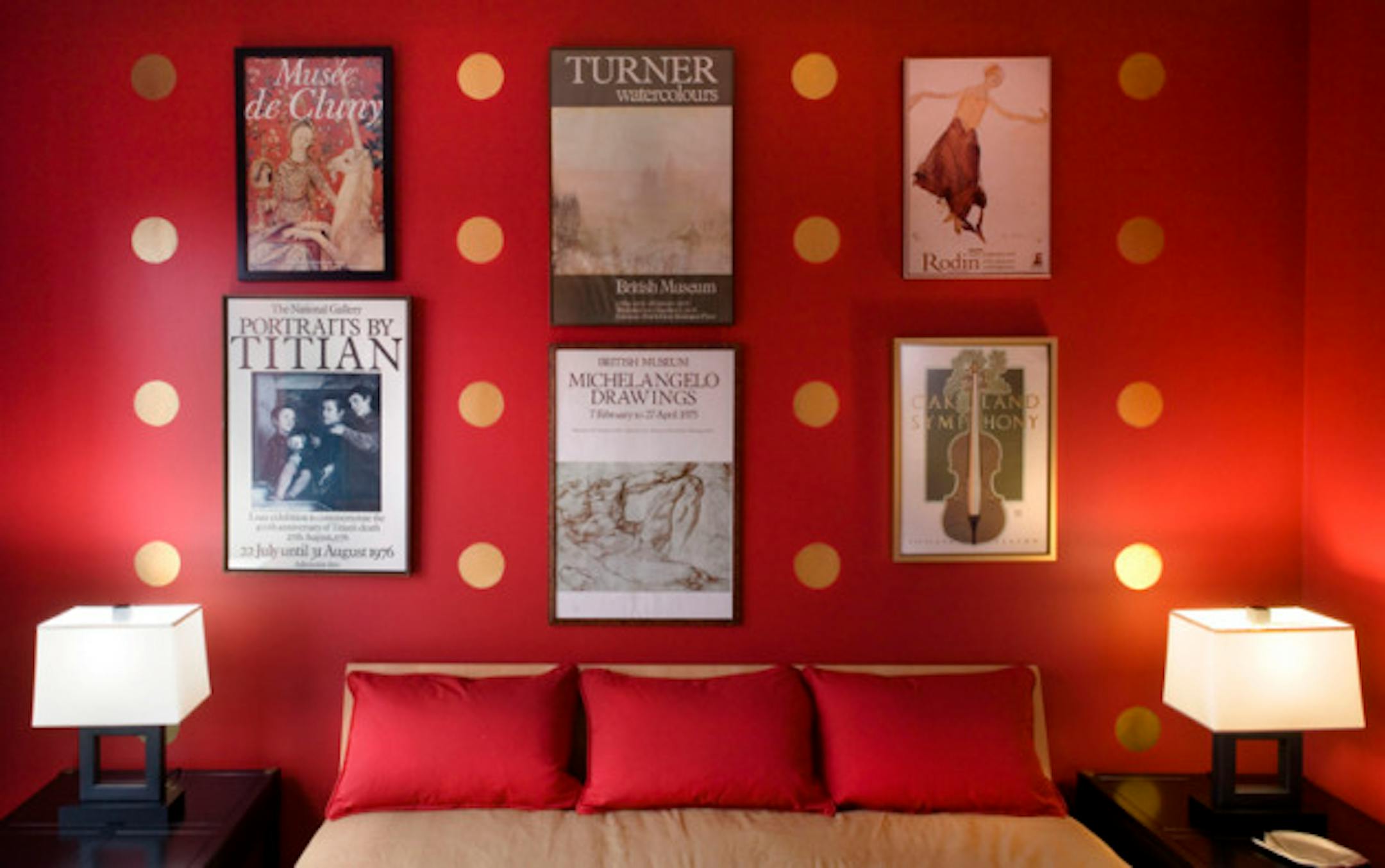 In this photograph, Geneva-based interior designer Madeline Roth displays how to hang art as seen in this master bedroom with red wall accentuated with gold circles and art posters. (Bill Hogan/Chicago Tribune/MCT)