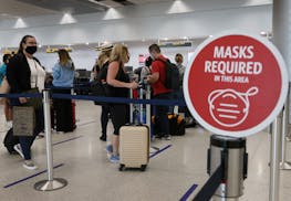 Masked travelers prepare to check-in for their flights at the Miami International Airport on Feb. 1, 2021.