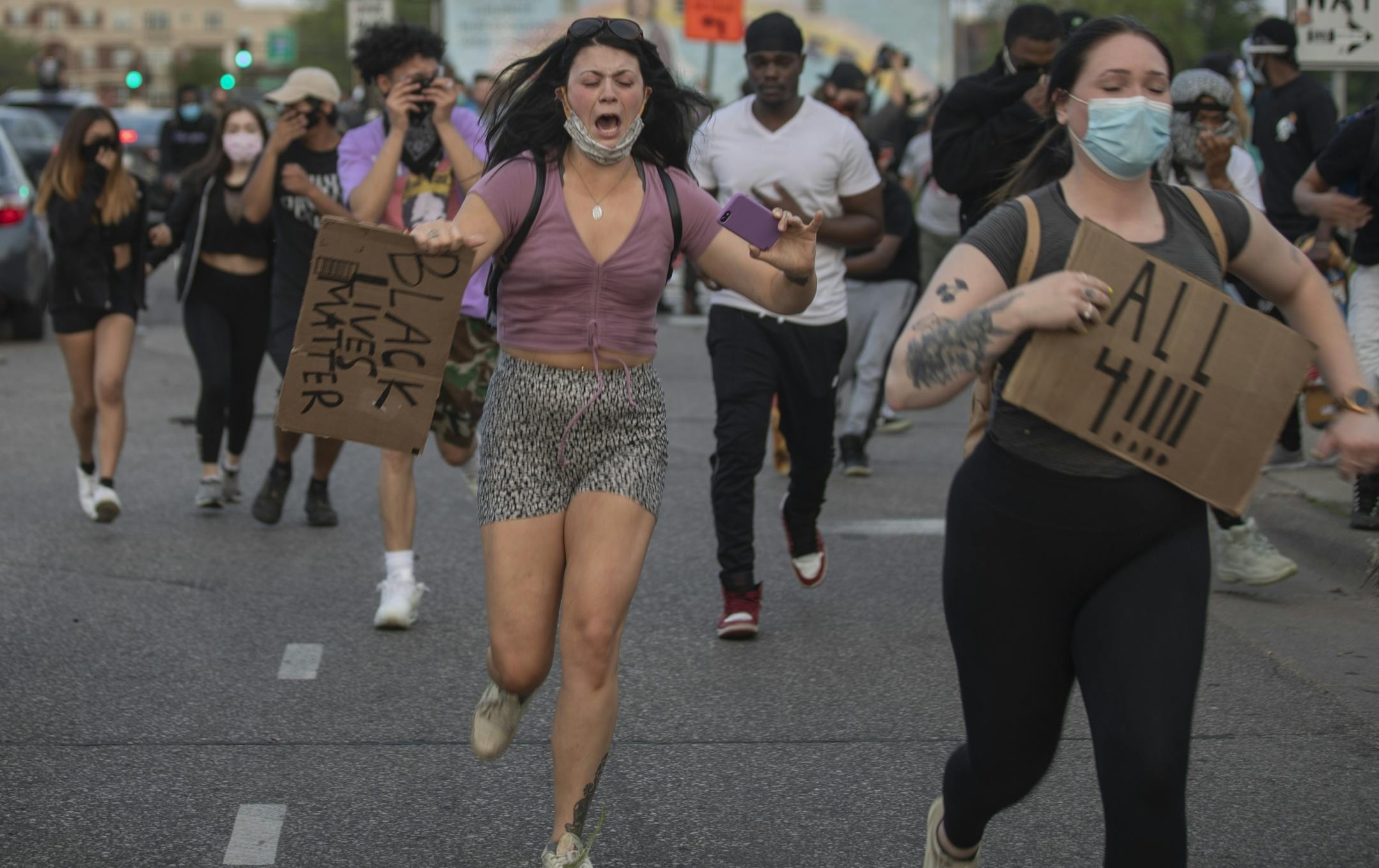 Protesters down Washington Ave away from tear gas Sunday night in downtown Minneapolis .