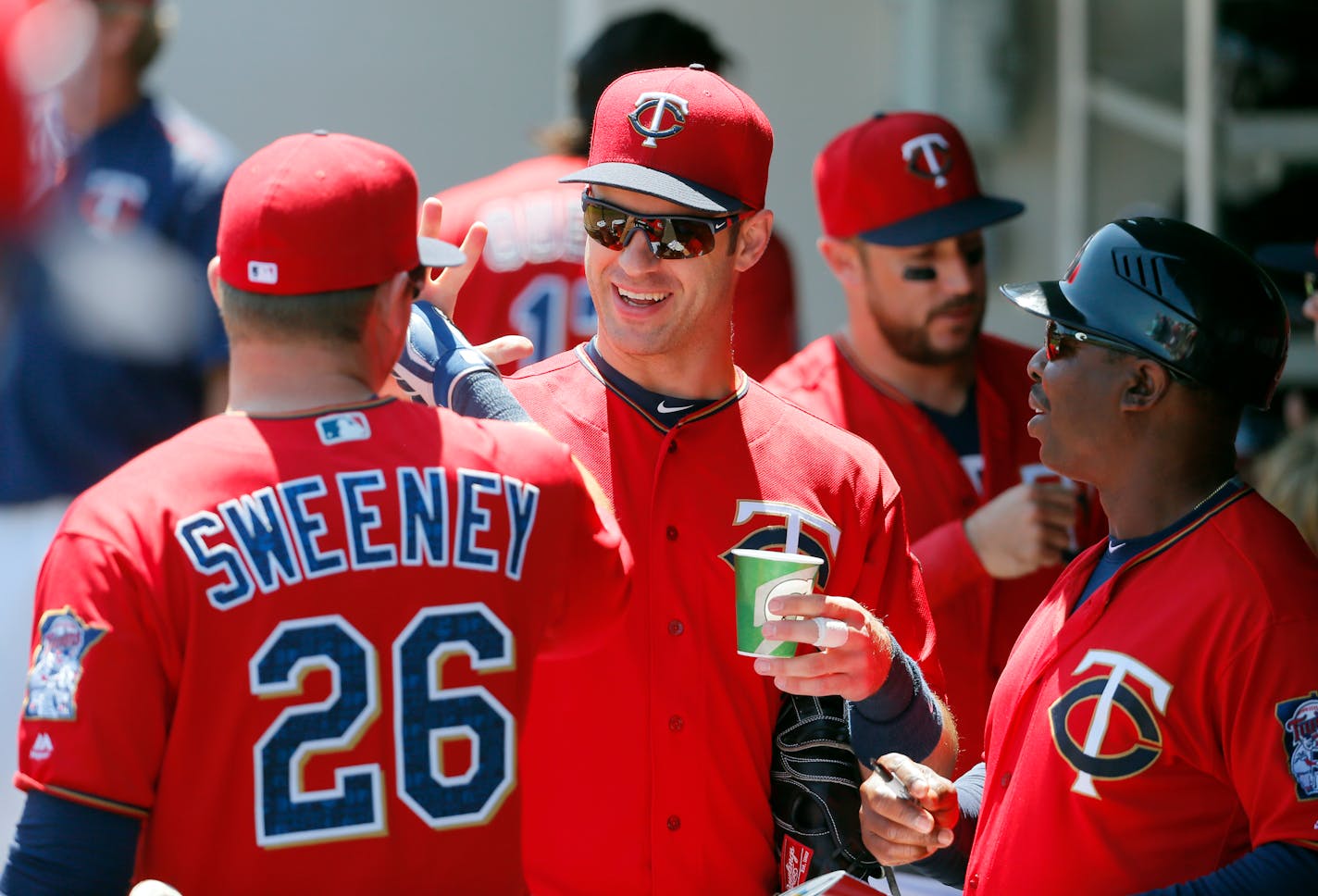 Minnesota Twins' Ryan Sweeney (26), Joe Mauer, center, and first base coach Butch Davis, right, greet each other in the dugout before a spring training baseball game against the Baltimore Orioles on Tuesday, March 22, 2016, in Fort Myers, Fla. (AP Photo/Tony Gutierrez)