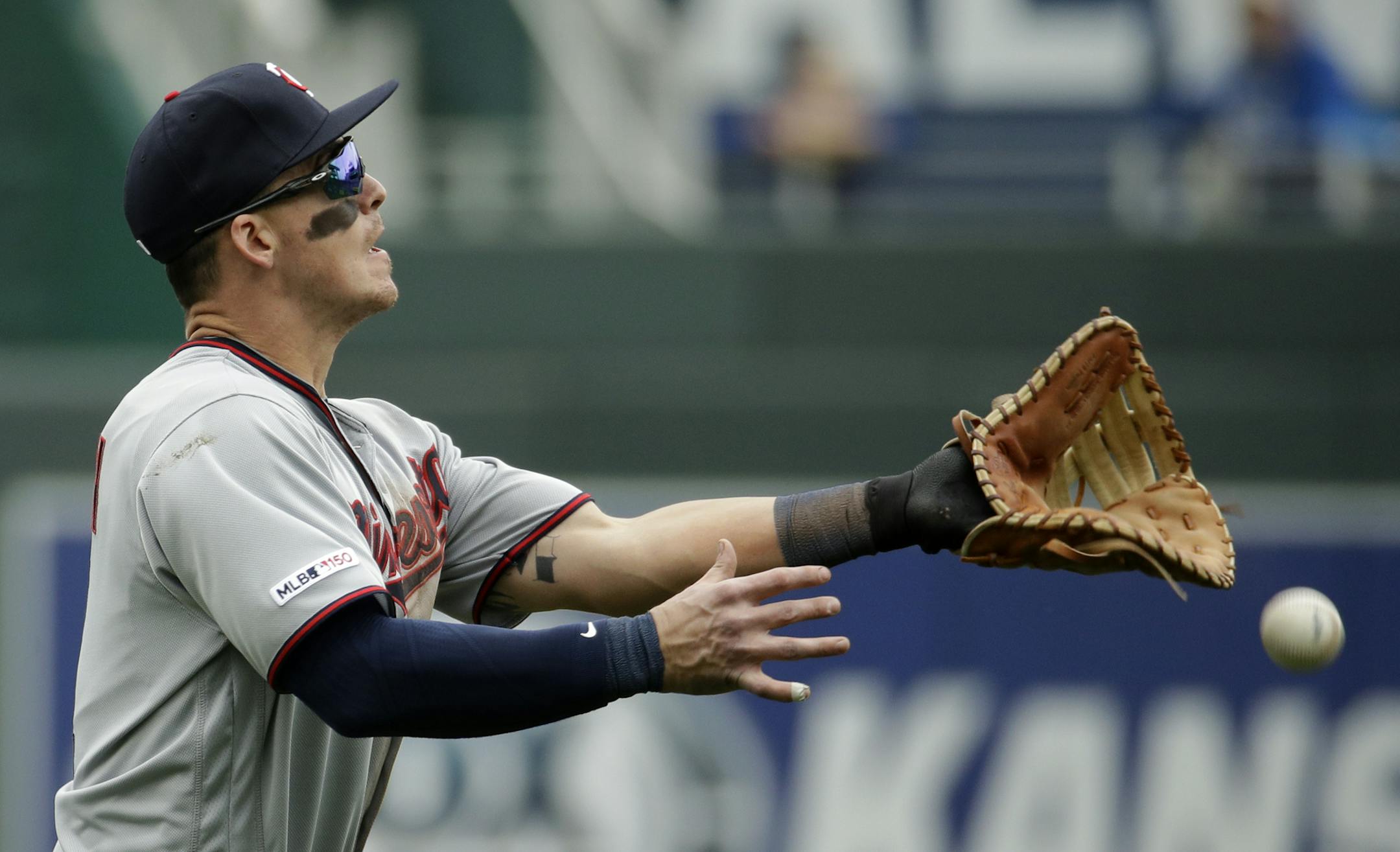Minnesota Twins first baseman Tyler Austin can't make the catch on a single by Kansas City Royals' Martin Maldonado during the eighth inning of a baseball game Wednesday, April 3, 2019, in Kansas City, Mo. (AP Photo/Charlie Riedel)