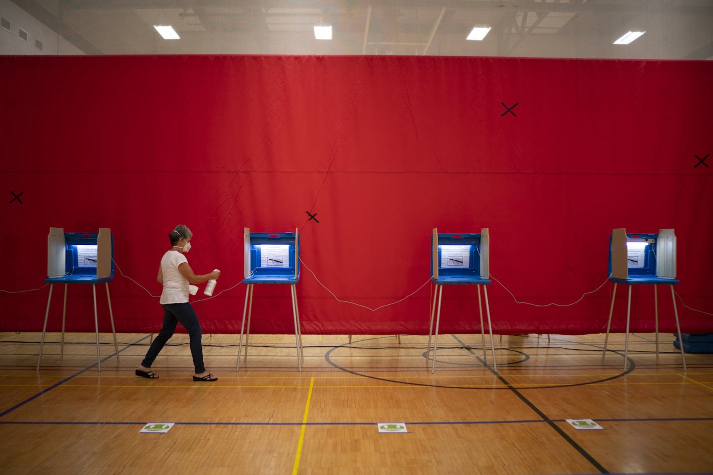 Voting judge Johanna Boller cleaned the voting booths after used in the gymnasium at Highland Park Middle School where Ward 3, Precinct 14 voters cast their votes in the primary election. ] JEFF WHEELER • jeff.wheeler@startribune.com Voter turnout appeared slow but steady at the two precincts voting at Highland Park Middle School Tuesday evening, August 11, 2020 in St. Paul.