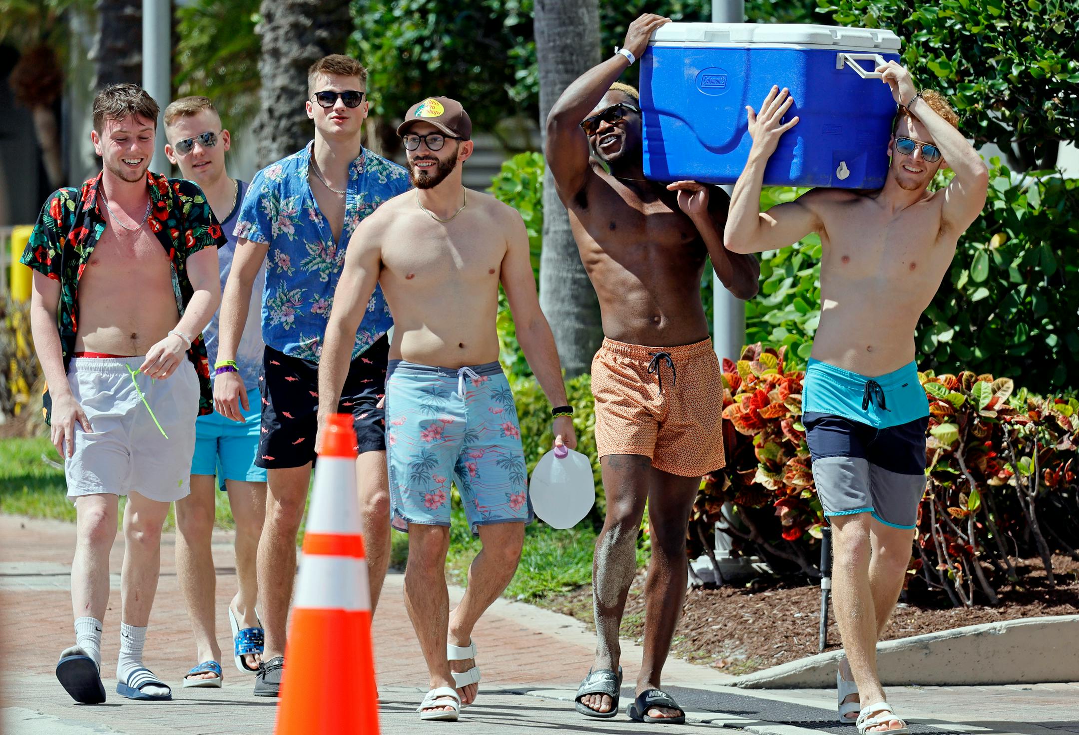 Beachgoers carry a cooler down Poinsettia Street during Spring Break on Fort Lauderdale Beach, Fla., on Tuesday, March 8, 2022. (Amy Beth Bennett/South Florida Sun-Sentinel via AP)