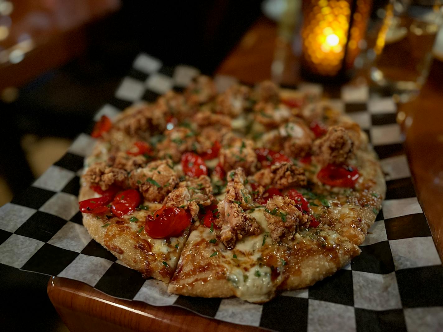 Fried chicken pizza topped with cheese and red pickled peppers.