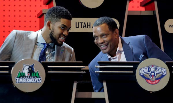 Minnesota Timberwolves center Karl-Anthony Towns, left, talks with New Orleans Pelicans head coach Alvin Gentry before the start of the NBA basketball