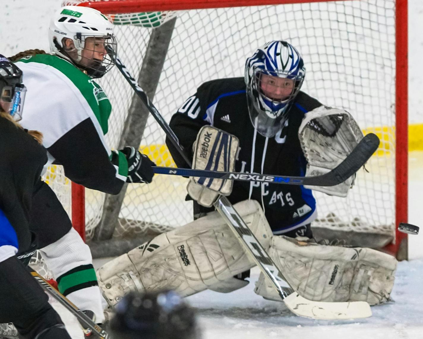 Hill-Murray';s Amber Peterson, middle, tipped the puck past Dodge County goalie Gabby Suhr in the Pioneers'; 4-1 victory.