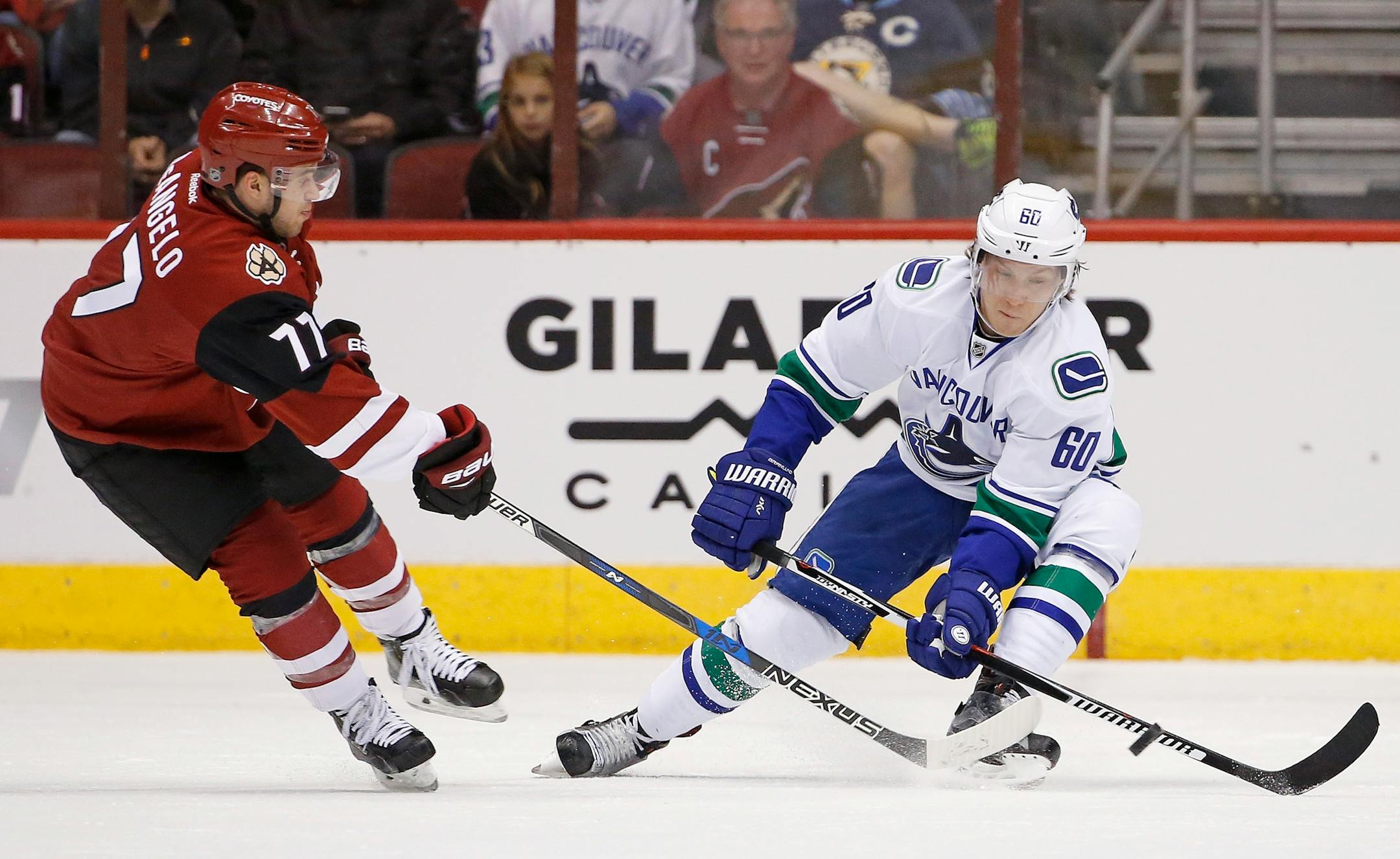 Arizona Coyotes defenseman Anthony DeAngelo (77) gets off a pass past Vancouver Canucks center Markus Granlund (60) during the first period of an NHL hockey game Wednesday, Nov. 23, 2016, in Glendale, Ariz. The Canucks defeated the Coyotes 4-1. (AP Photo/Ross D. Franklin)