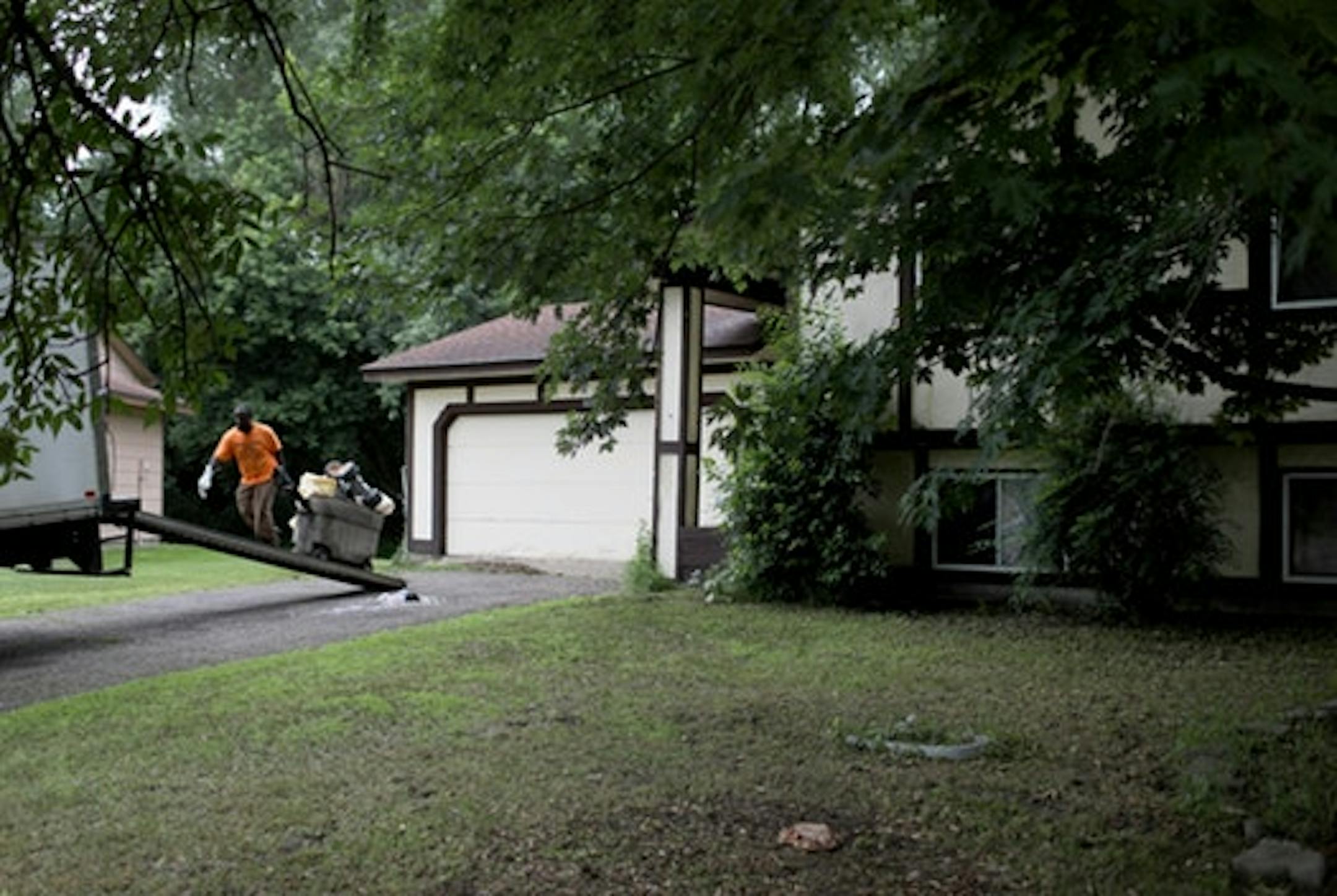 A worker from Kaba Junk Removal, who declined to give his name, removes toys and other belongings from the home Tuesday, June 19, 2018, in Brooklyn Park, Minn.