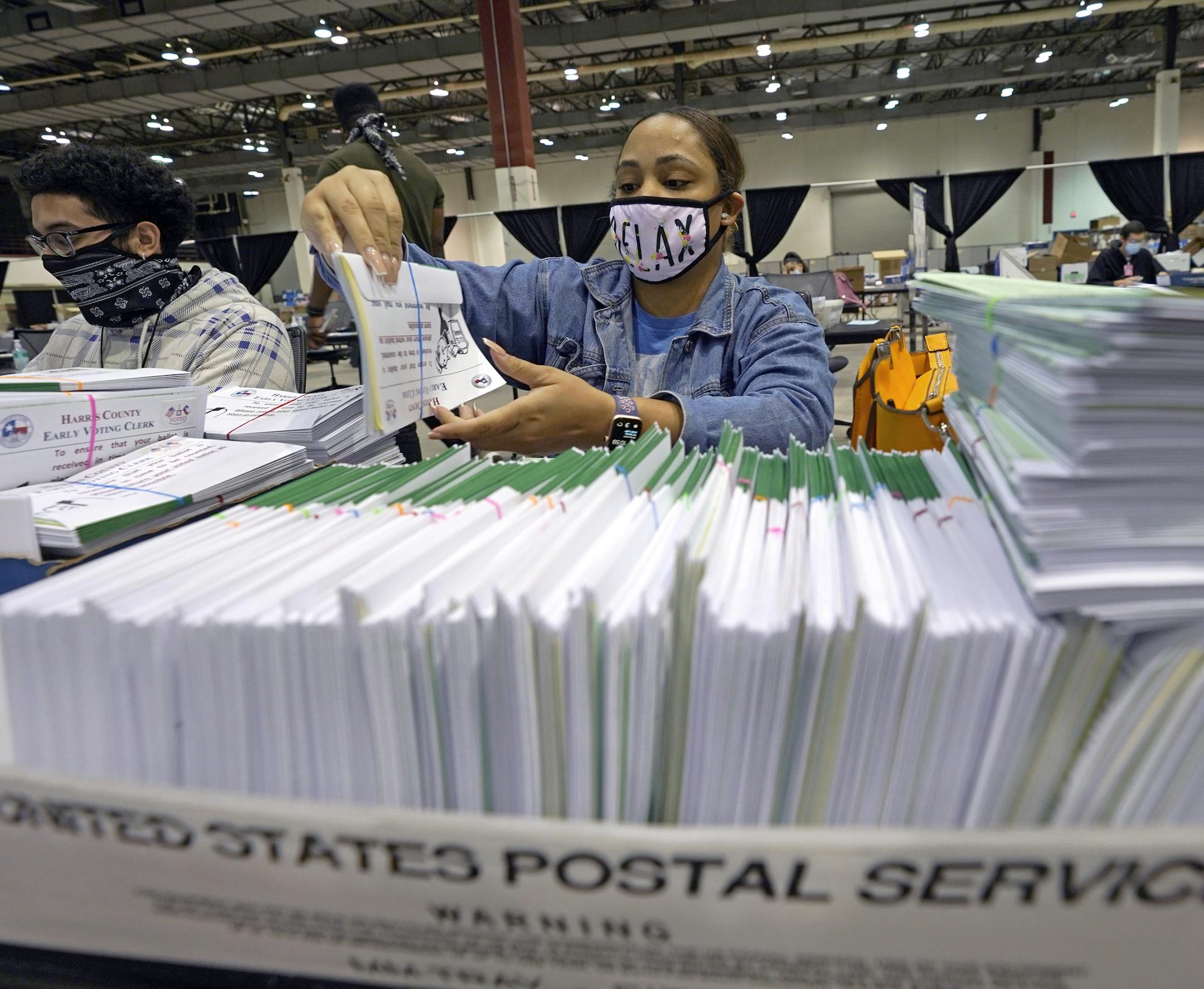 Harris County election worker Romanique Tillman prepares mail-in ballots to be sent out to voters Tuesday, Sept. 29, 2020, in Houston. Texas is one of just a handful of states that declined to expand absentee voting this year because of the the coronavirus pandemic. (AP Photo/David J. Phillip)