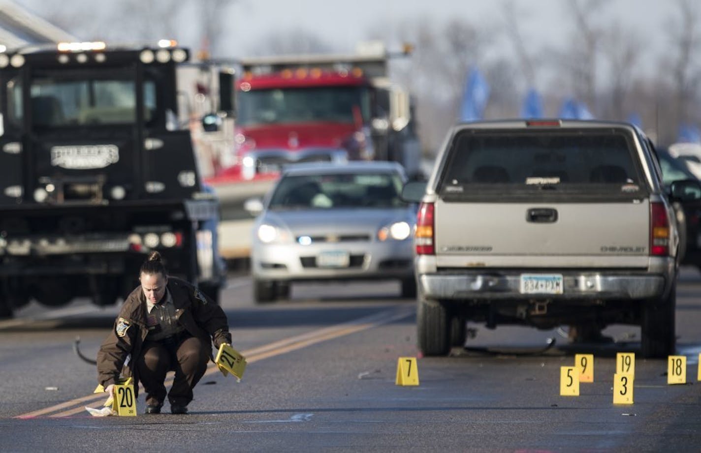 Wright County Sheriff's Office officials investigate the scene where a pickup truck, at right, hit three Rogers High School students.