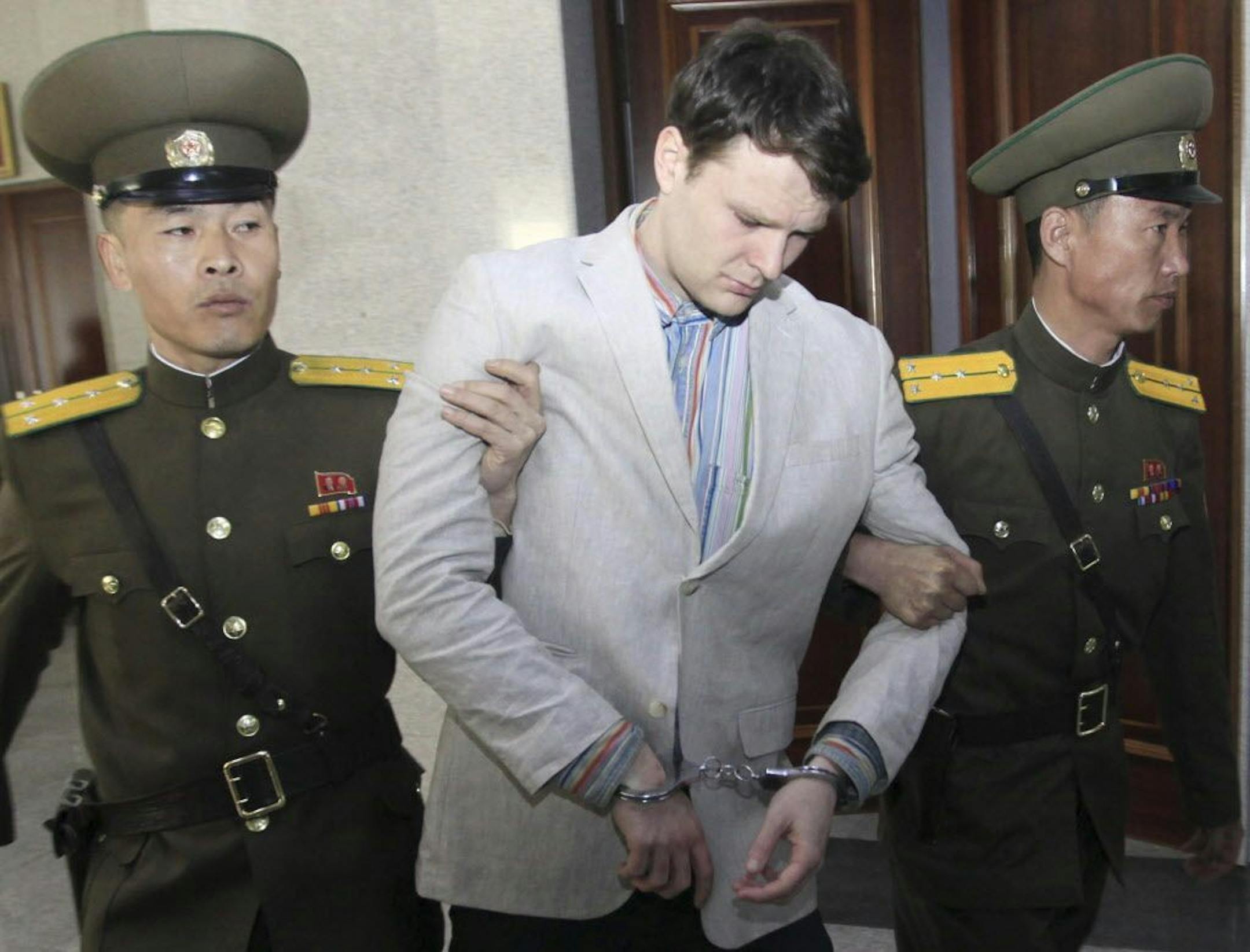 American student Otto Warmbier, center, was escorted at the Supreme Court in Pyongyang, North Korea, Wednesday, March 16, 2016.