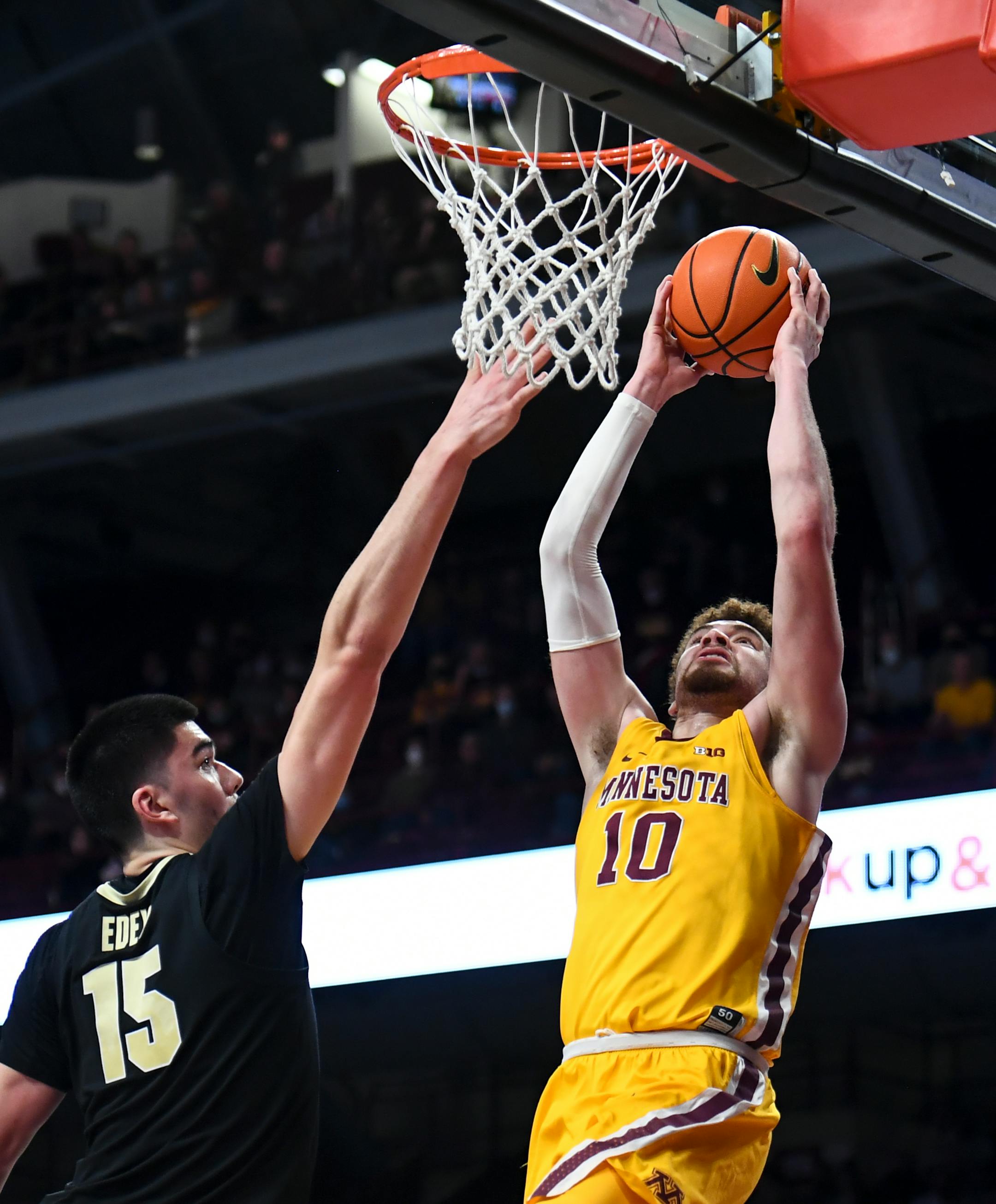 Minnesota Gophers forward Jamison Battle (10) dunks the ball against Purdue Boilermakers center Zach Edey (15) during the first half of an NCAA men's basketball game between Minnesota and Purdue at Williams Arena in Minneapolis, Minn.
